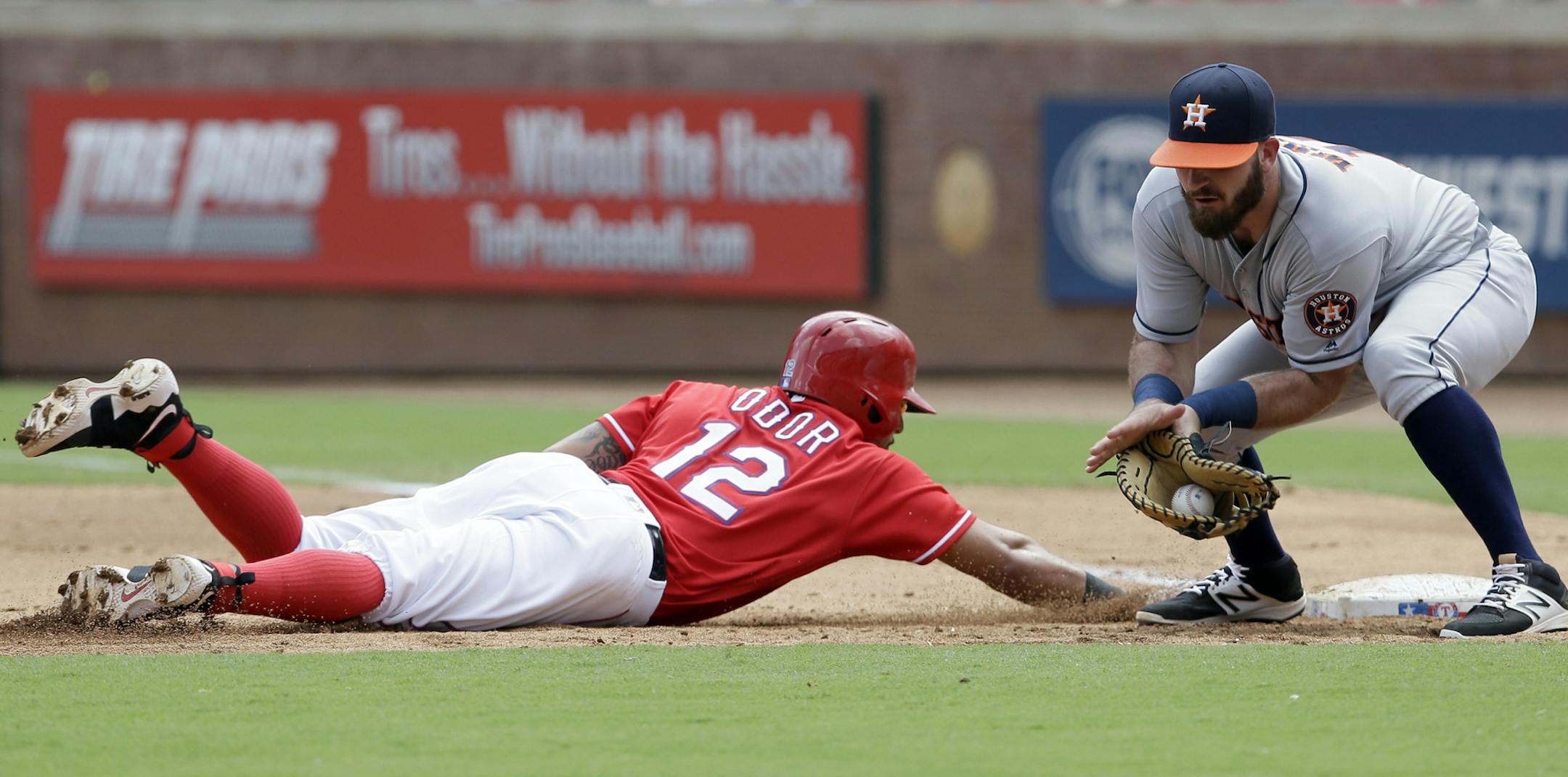 Texas Rangers Rougned Odor (12) beats the pick off throw to Houston Astros first baseman Tyler White, right, during the second inning of a baseball game in Arlington, Texas, Sunday, Sept. 4, 2016. (AP Photo/LM Otero)