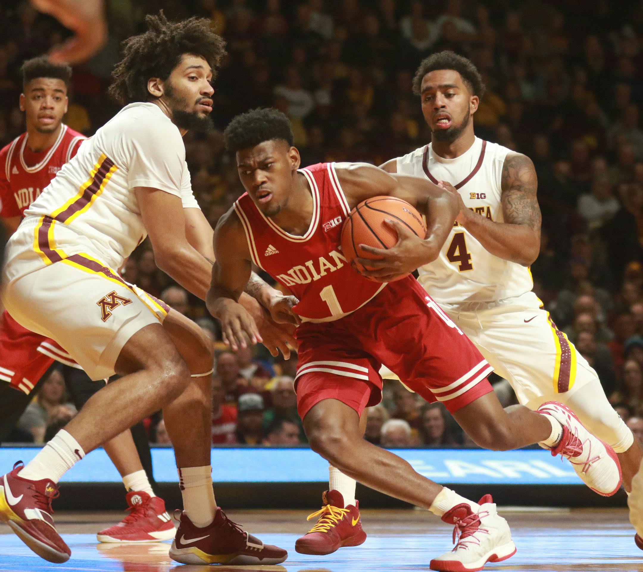 Jordan Murphy (3) and Jamir Harris (4) cover Indiana's Aljami Durham during the first half