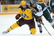 Minnesota Golden Gophers right wing Hudson Fasching (24) and Michigan State Spartans forward Ryan Keller (12) collided while chasing down the puck in 