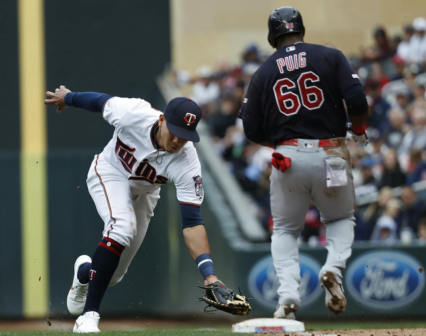 Ehire Adrianza (13) is late trying to retire Cleveland's Yasiel Puig on a play at first base.