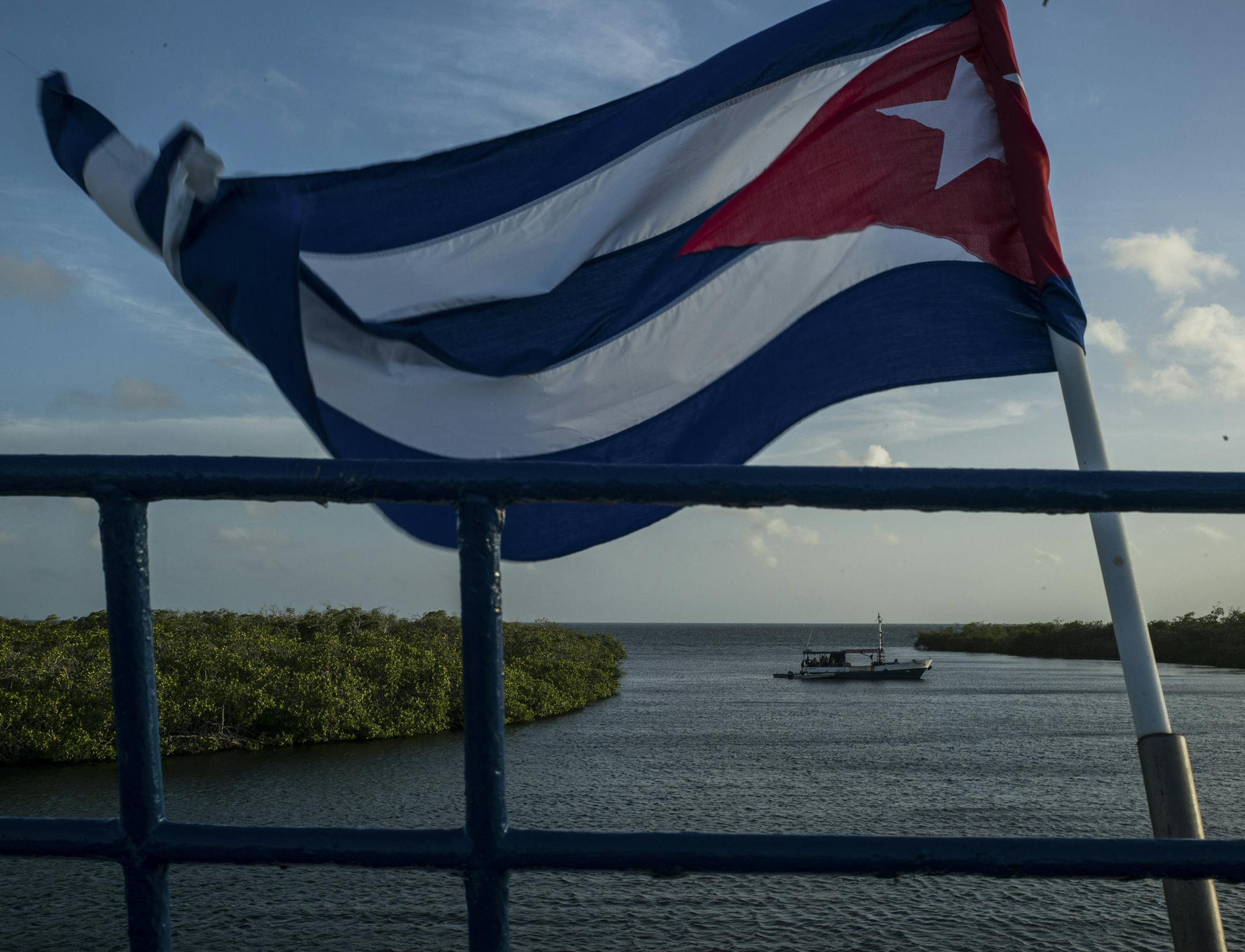 The Cuban flag flies on the deck of a floating hotel in Jardines de la Reina, a protected area south of Jucaro, Cuba, May 26, 2015. As relations between the U.S. and Cuba have warmed some fear development and tourism would result in the destroyed forests, polluted rivers and damaged coral reefs faced by some of Cuba’s neighbors.
