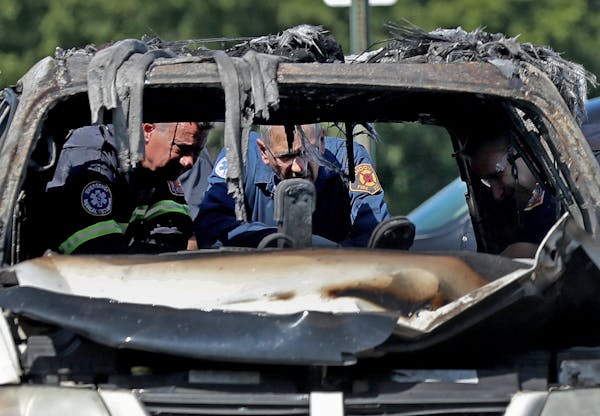 Fire investigators looked over the charred remains of a van Tuesday in a Fridley Walmart parking lot.