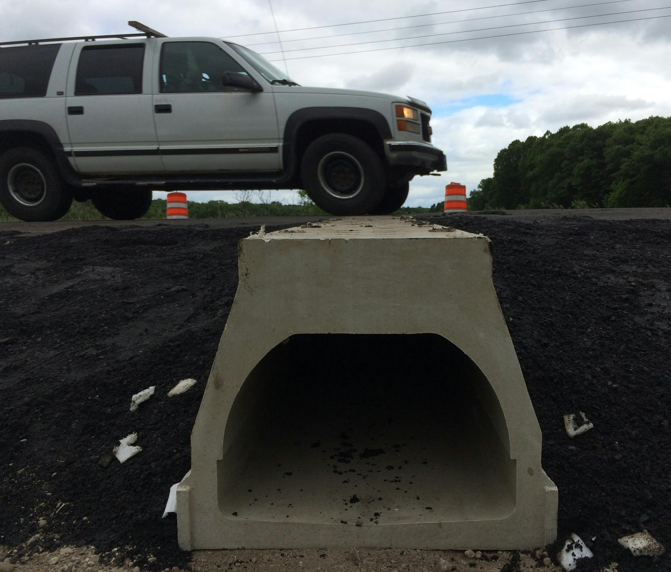 A sport utility vehicle drives across the "turtle tunnel" 170th Street in May Township, which officials hope will allow Blanding's turtles to make their way to and from wetlands on either side of the road.