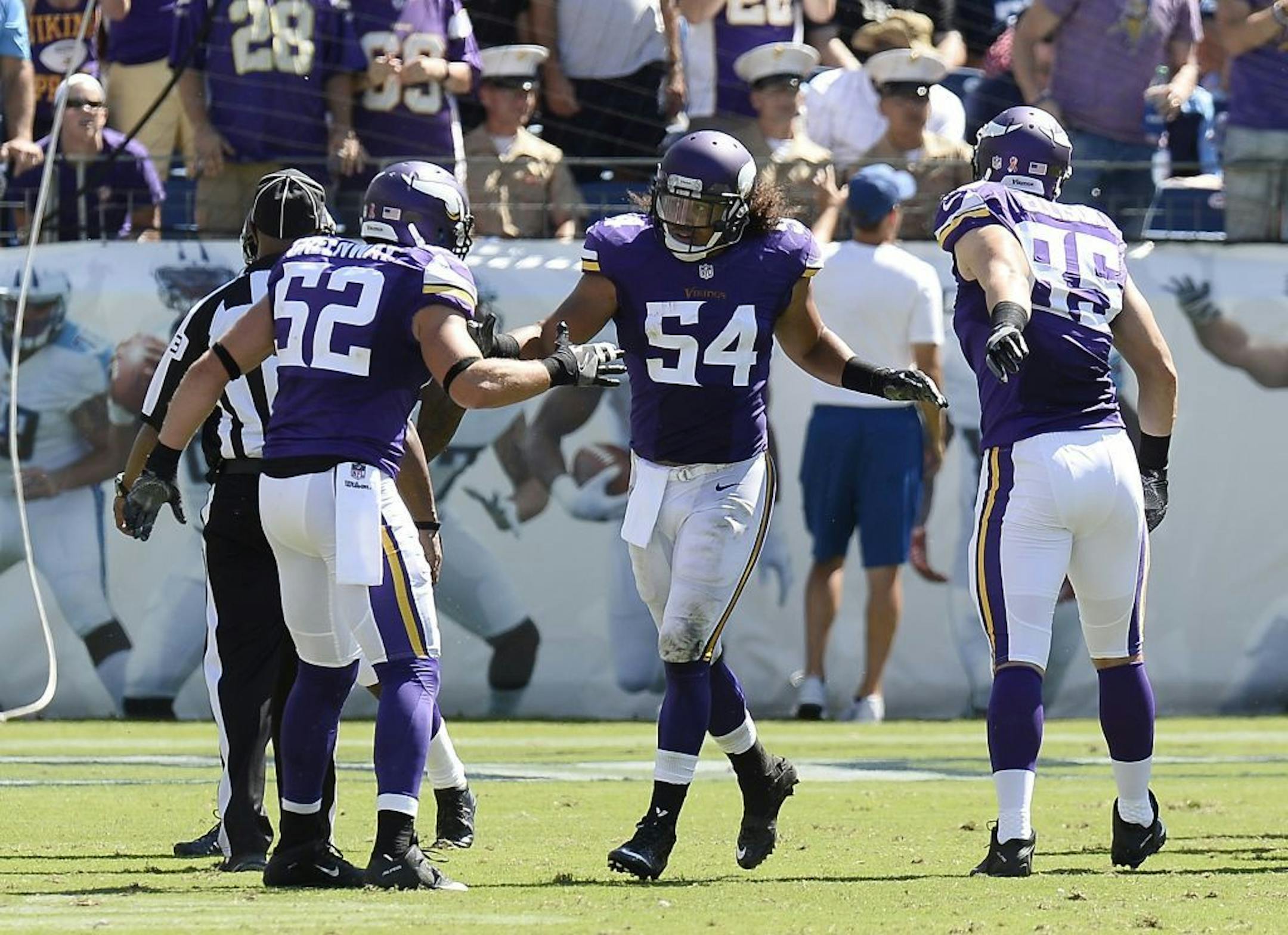 Minnesota Vikings linebacker Eric Kendricks (54) is congratulated by Chad Greenway (52) and Rhett Ellison (85) after Kendricks returned an intercepted pass 77 yards for a touchdown against the Tennessee