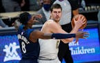Nuggets center Nikola Jokic looked to pass as Timberwolves forward Jarred Vanderbilt defended him Tuesday. Jokic didn't have to pass often, collecting