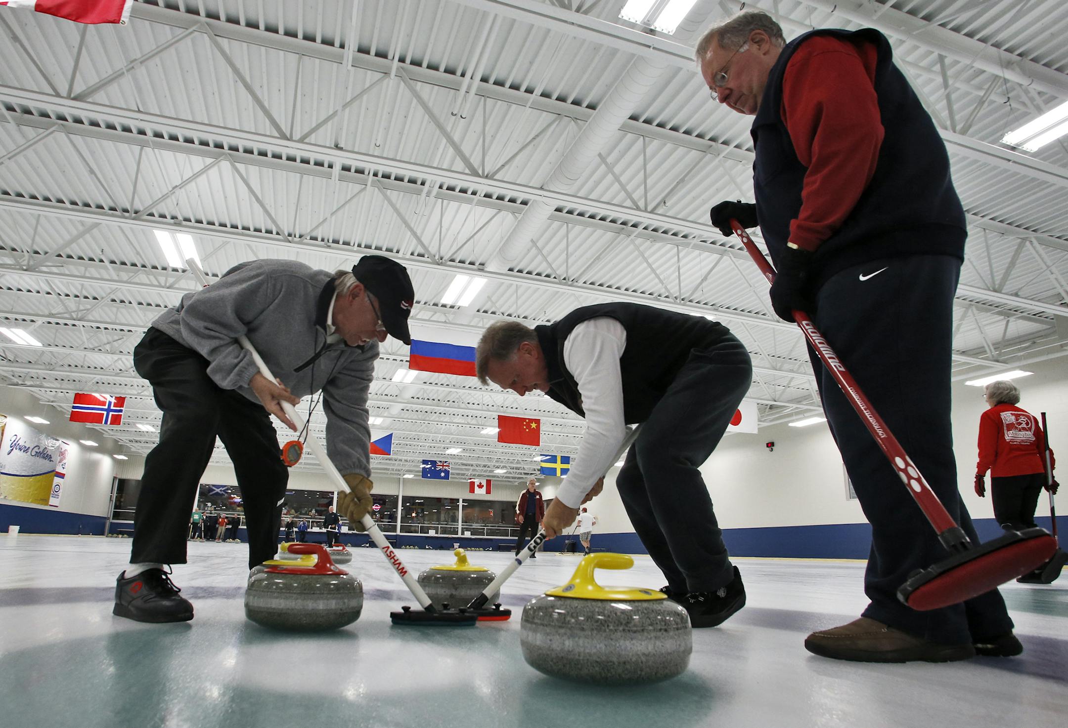 Curling activities at Fogerty Arena in Blaine. St. Paul Curling Club (SPCC) competed against Doug White team from New Hope. Gary Weaver and Jerry Madier, l-r, of Doug White team sweep the rock into position, as Doug white, right, looked on. (MARLIN LEVISON/STARTRIBUNE(mlevison@startribune.com (cq )