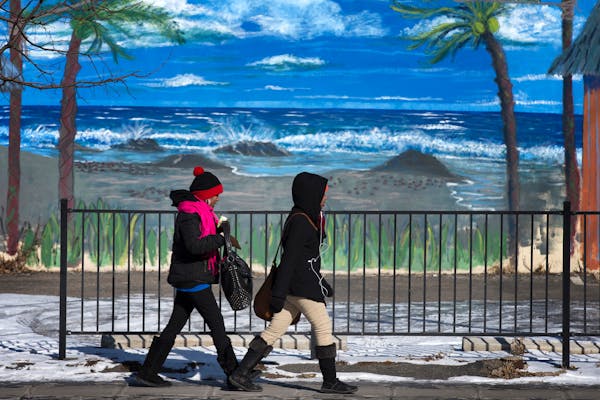 Pedestrians walks by a mural as temperatures hovered around 0 degrees in Minneapolis on Thursday, Feb. 19, 2015. The National Weather Service issued a