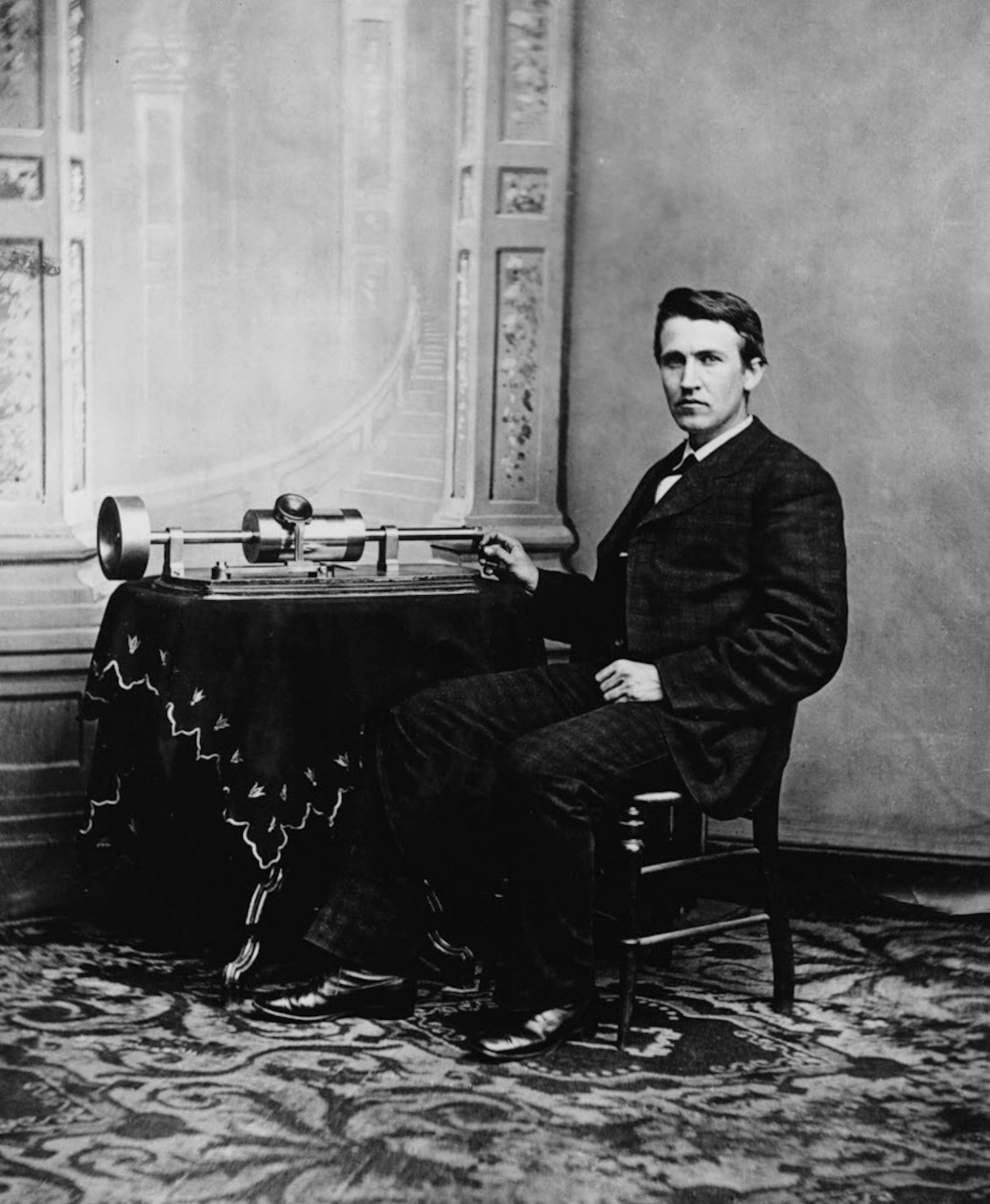 Thomas A. Edison is shown with the tin-foil phonograph of his invention. Historical photo, approx 1877 or 1878.