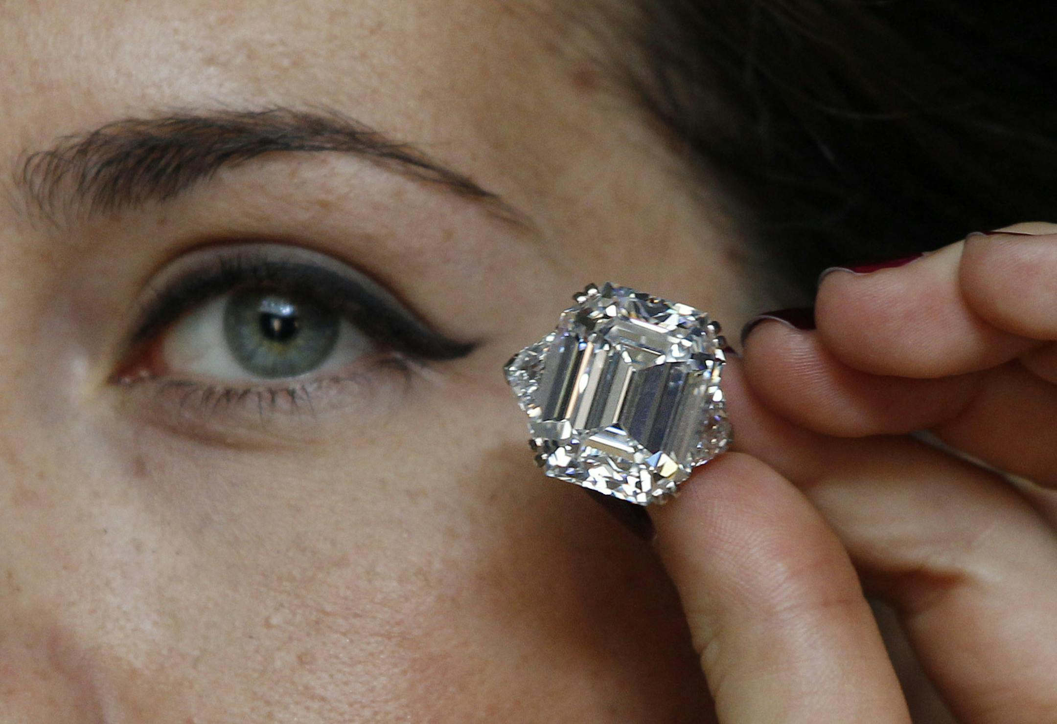 An auction house worker poses for the photographers in central London, Thursday, March 29, 2012 holding a 34.05 carat rectangular-cut diamond ring, estimated to fetch some US$3.6-5 million in an upcoming auction. Christie's auction house will hold the 'Jewels For Hope: The Collection of Mrs. Lily Safra' sale in Geneva, Switzerland on May 14, 2012. The overall estimate for the collection is in excess of $US20 million. (AP Photo/Lefteris Pitarakis)