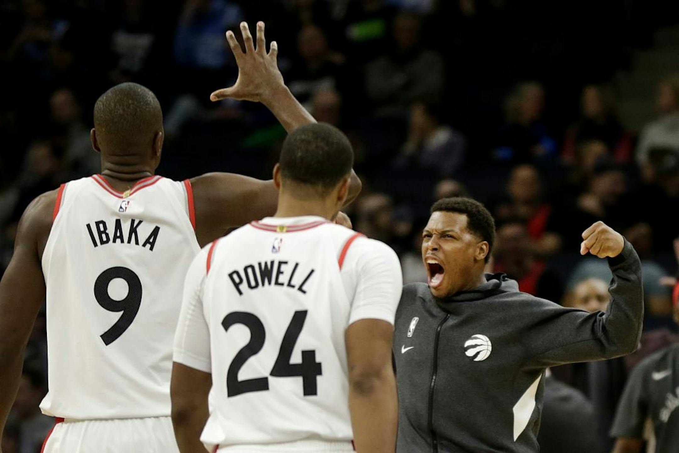 Toronto Raptors guard Kyle Lowry, right, flexes while celebrating Raptors center Serge Ibaka's (9) dunk against the Minnesota Timberwolves while teammate Norman Powell walks off in the fourth quarter of an NBA basketball game Saturday, Jan. 18, 2020, in Minneapolis.