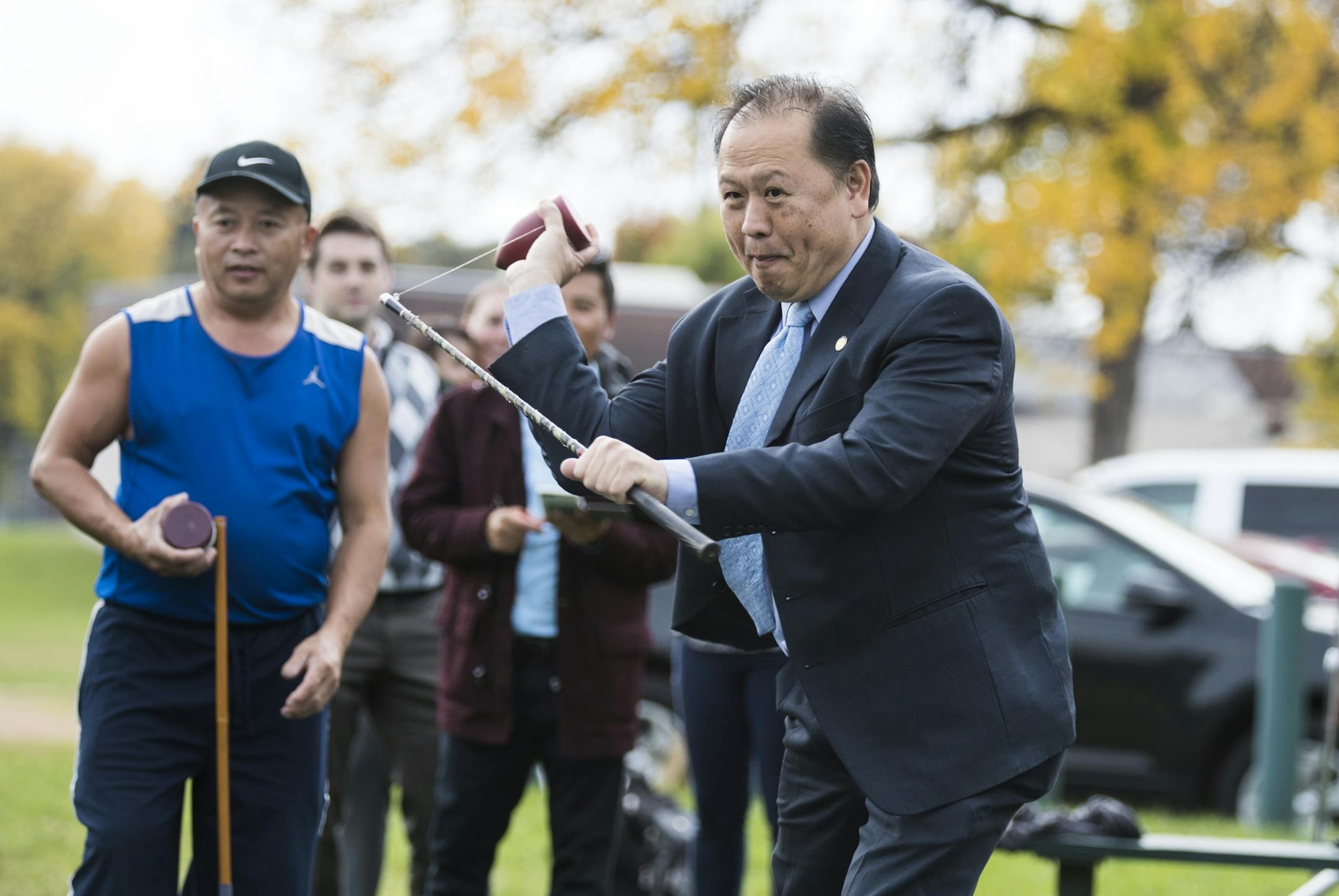 State Senator Foung Hawj, (DFL) District 67, tries his hand at the game of Tuj Lub during the grand opening of the courts in St. Paul.