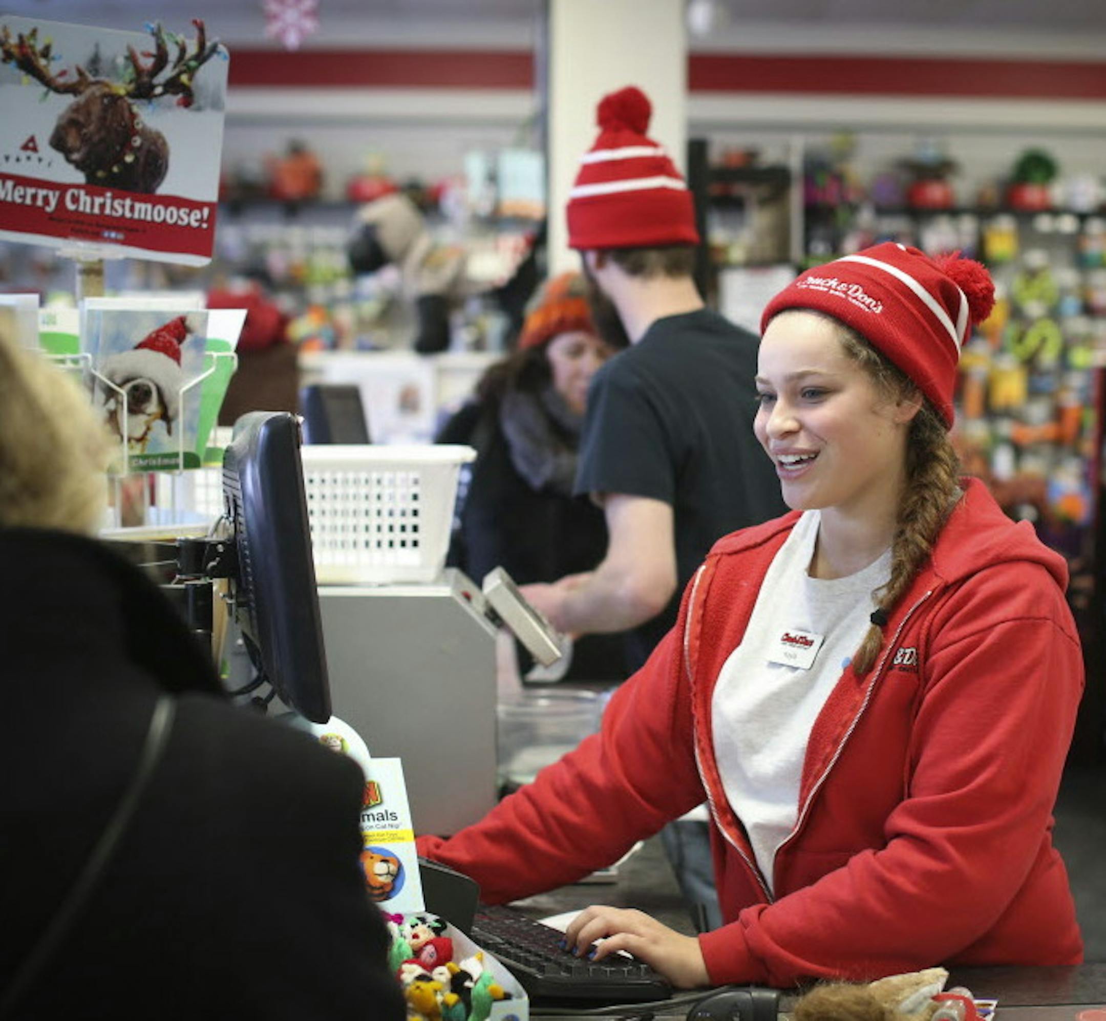 Kayla Salsberg explained to a customer how her donation to the paw print fundraiser will in part go to raising money for a gas mask fr dogs on fire trucks at Chuck and Don's Pet Food and Supplies in Minneapolis, Minn. on Friday, December 19, 2014. ] REN&#xc9;E JONES SCHNEIDER reneejones@startribune.com