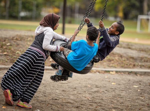 Children played on a tire swing in Matthews Park, Minneapolis.