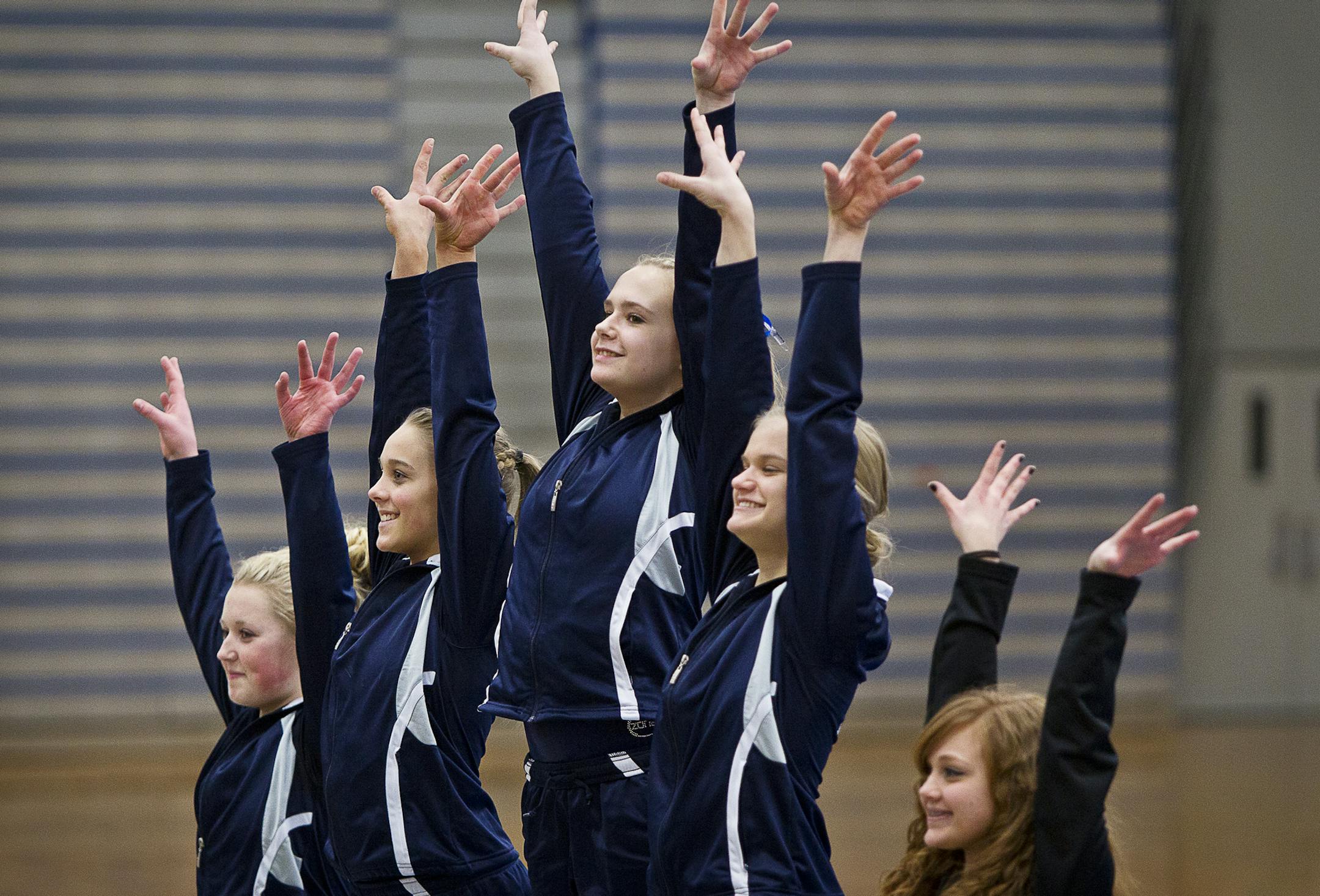 Left to right, Champlin Park's Kayla Uzzell, Taylor Guckeen, Liz Hammond, Amanda Cunningham and Coon Rapids' Kali Lawerence wave from the podium of the vault competition after the dual gymnastics meet between Champlin Park High School and Coon Rapids High School at Champlin Park, Friday, January 31, 2014. Champlin Park won the meet with a combined score of 137.35 over Coon Rapids' 125.975. [ BEN BREWER ‚Ä¢ Special to the Star Tribune _ DATE 1/31/2014 SLUG: PNORTH020514 EXTRA INF
