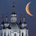 The moon rises in the sky above the domes of the Smolny Cathedral in St.Petersburg, Russia, Friday, April 25, 2014. One of St. Petersburg landmarks, t