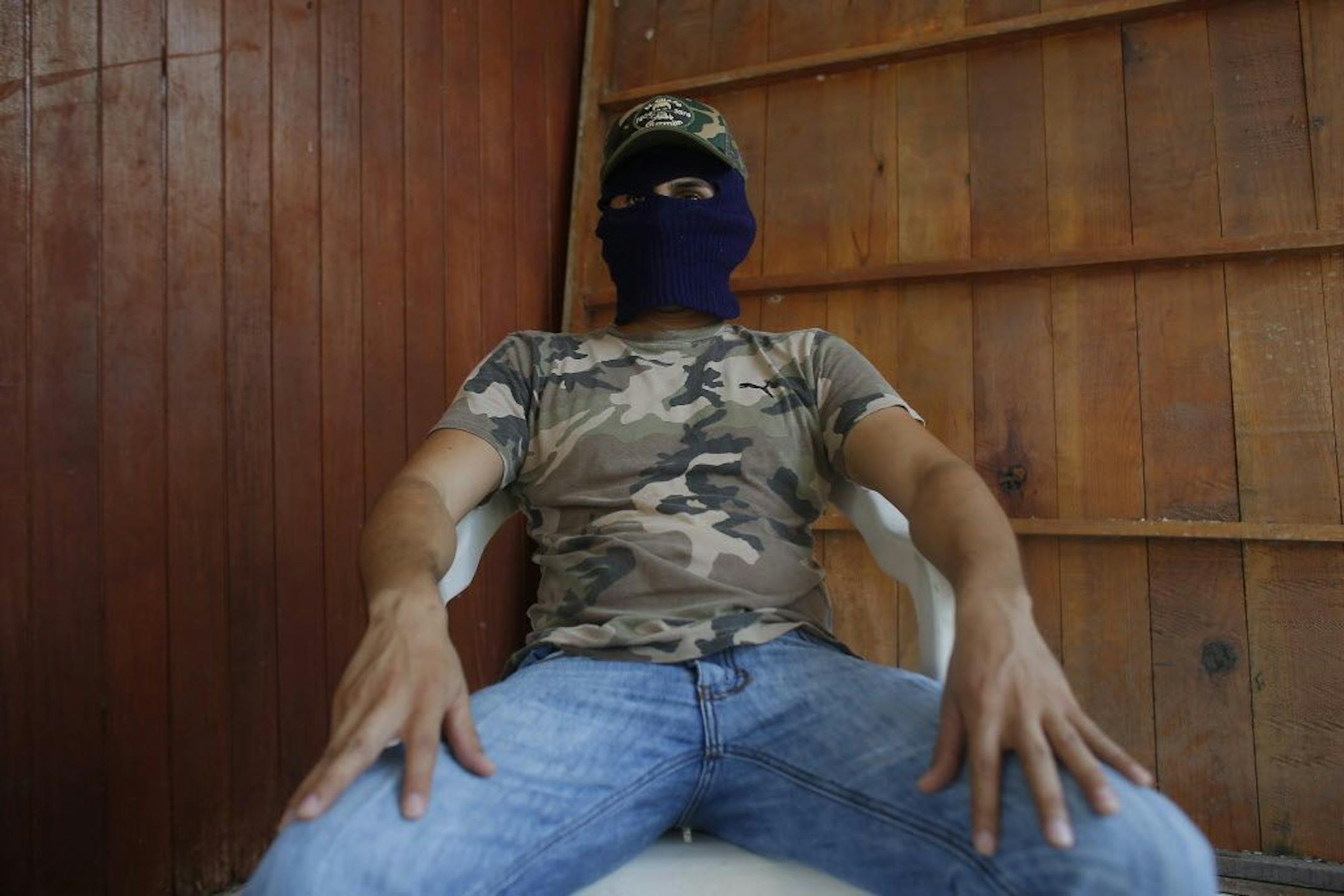 In this Nov. 29, 2015 photo, a man claiming to be responsible for kidnapping, torture and killing on behalf of a drug cartel speaks to the Associated Press in Guerrero state's Costa Grande region, Mexico.