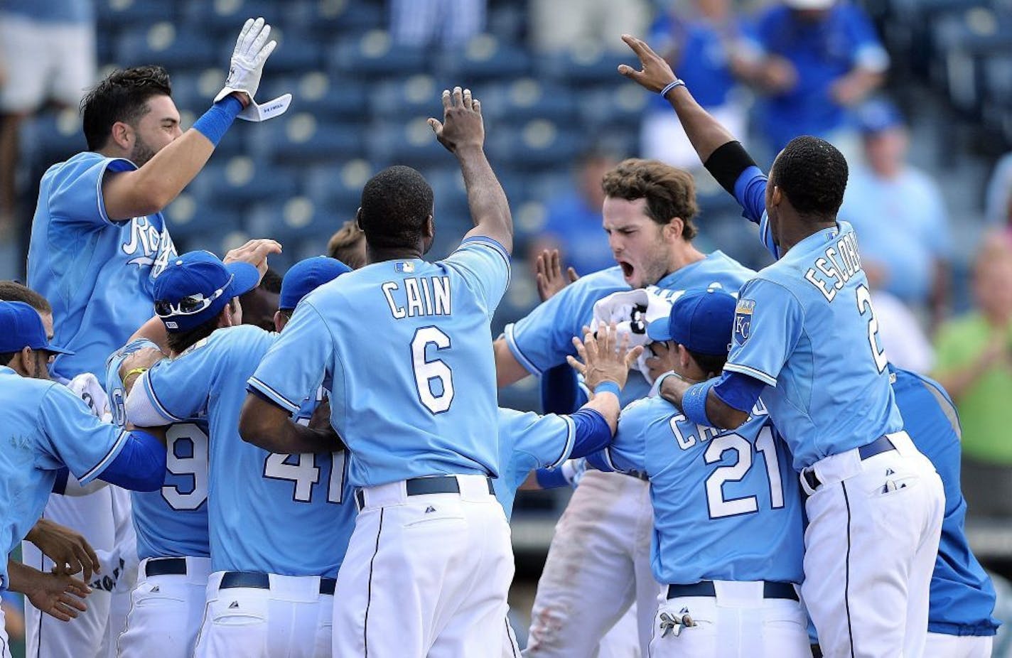 Kansas City Royals' Mike Moustakas (8) celebrates with the team at home plate after hitting the game-winning home run in the 13th inning against the Seattle Mariners on Thursday, September 5, 2013, in Kansas City, Missouri.