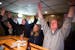 Bangor residents hold up their arms to mark the end of happy hour at Bangor Lanes as the 6 p.m. village siren wails in Bangor, Wis. on Tuesday, Januar