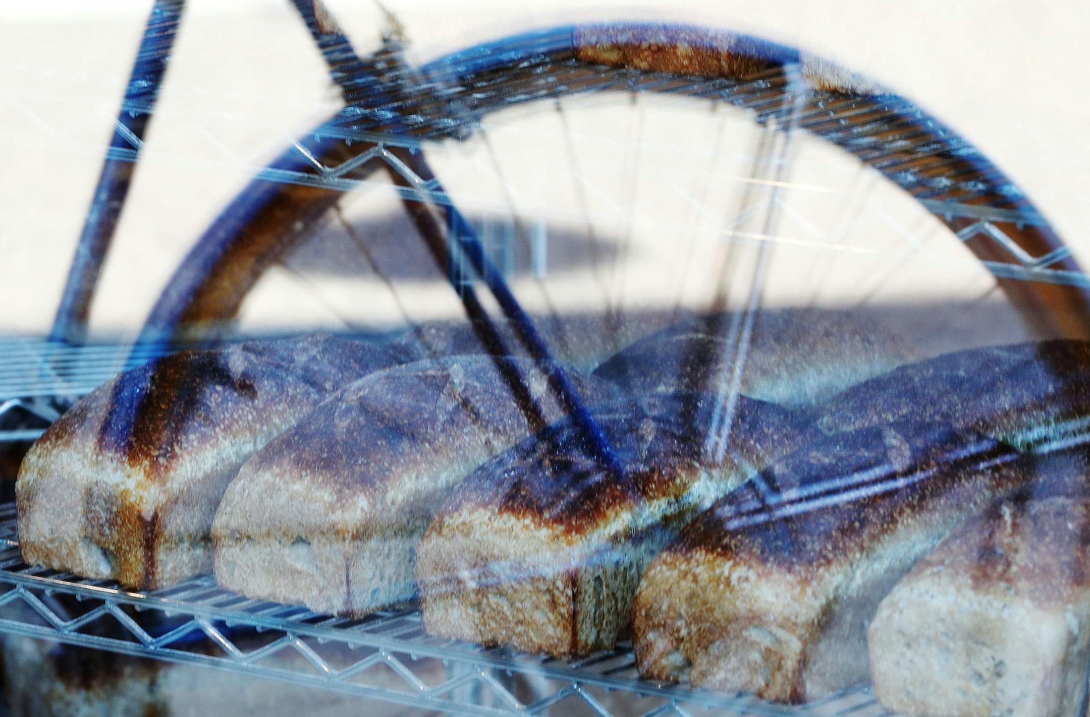 The bike of co-owner and baker Nate Houge is reflected in the window of Brake Bread as loaves of fresh cracked wheat sit on a rack. Brake Bread is an artisanal bakery that got it's start delivering bread to the area by bicycle and is now located on W. 7th near downtown and seen Thursday, Sept. 1, 2016, in St. Paul, MN.](DAVID JOLES/STARTRIBUNE)djoles@startribune Brake Bread, a new W. Seventh Street bakery, has humble beginnings: from a basket rigged to a bicycle. That's not where they baked thei