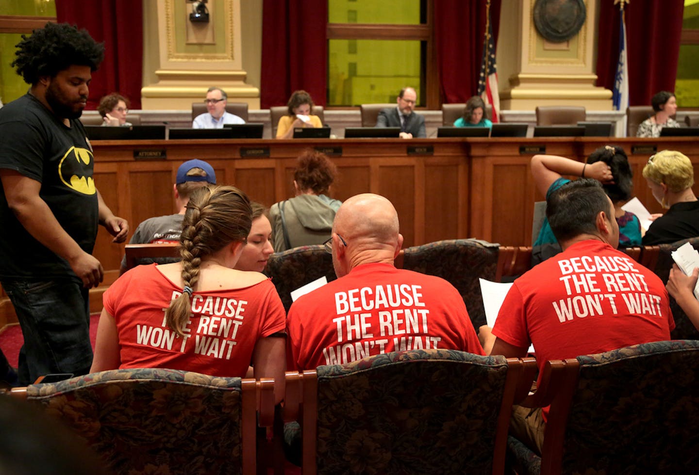 In this 2017 file photo, supporters of a $15 Minneapolis minimum wage confer as a Minneapolis City Council committee considers the issue.