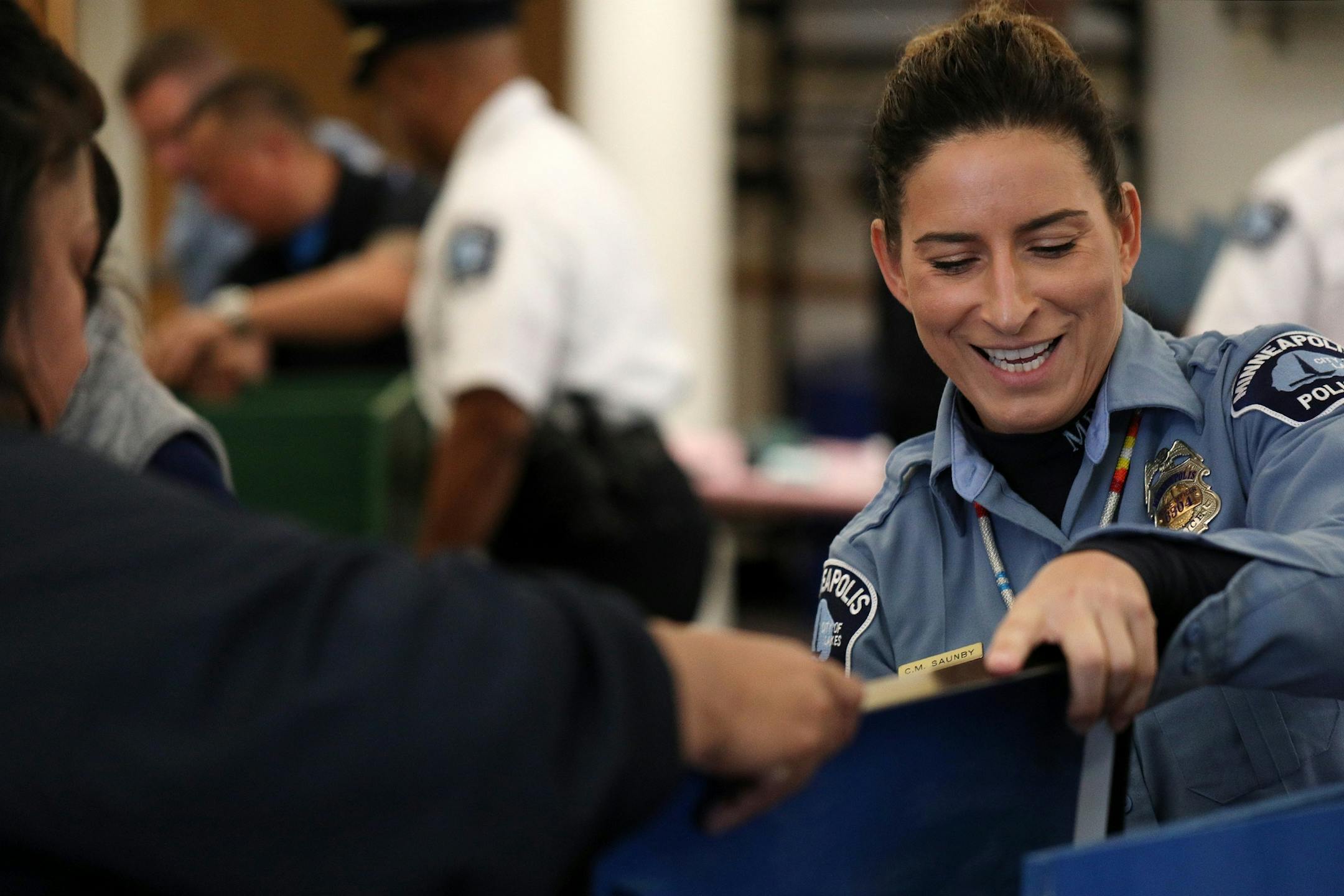 Police officer Colleen Saunby laughed as she worked alongside other officers to build free-standing Little Free Libraries Tuesday.