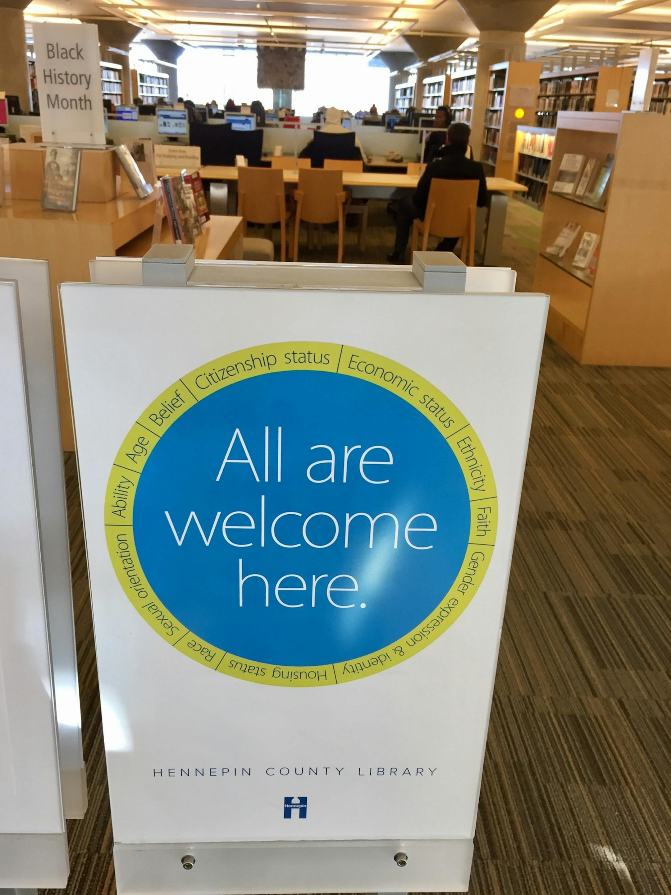 Signs posted in the Hennepin County Library state that people are welcome there, no matter their citizenship status, faith, race, etc.