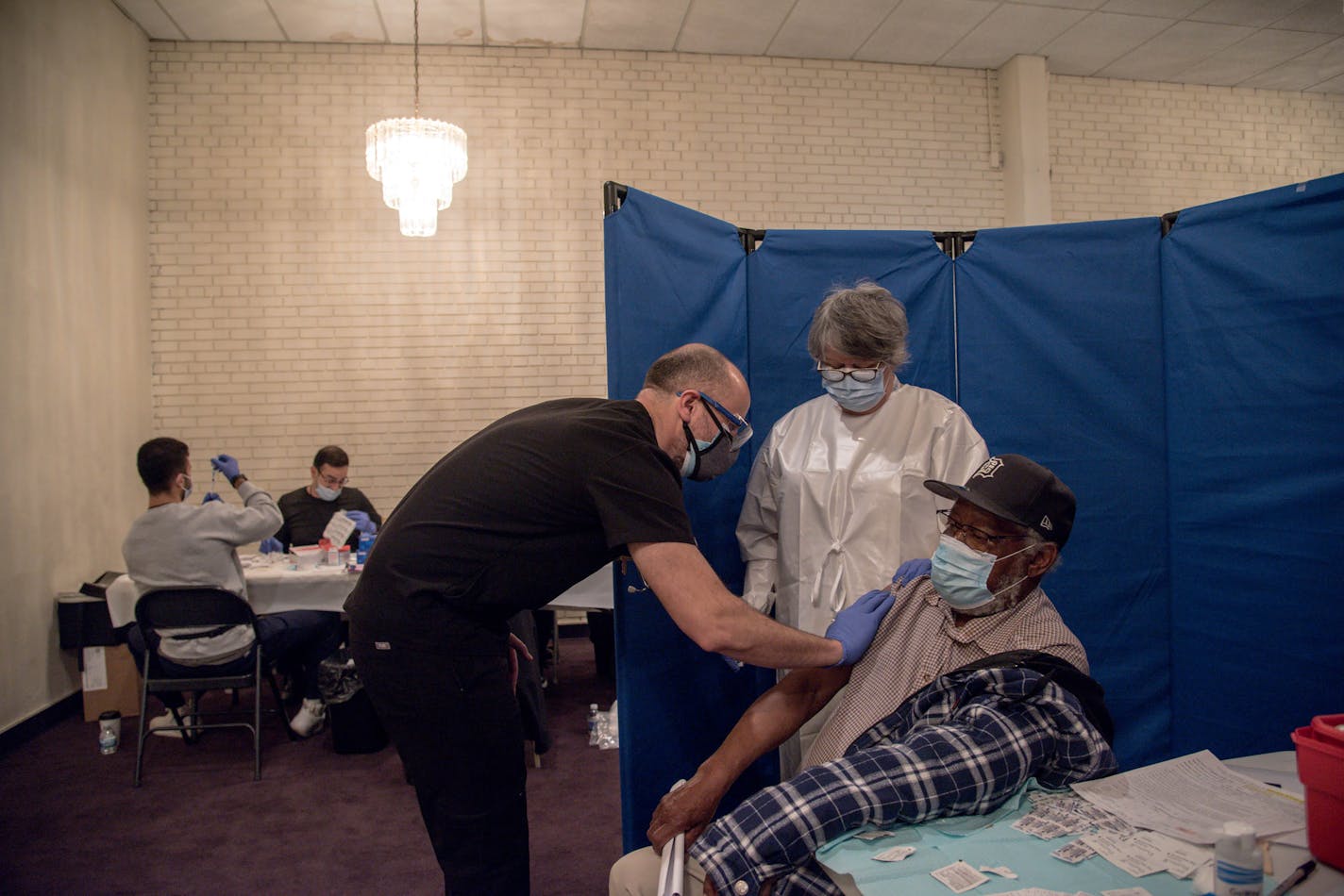 FILE — A patient, right, after receiving a COVID-19 vaccine at a vaccination site at Greater Emmanuel Institutional church in Detroit, on March 27, 2021. Biden administration officials now say older or immunocompromised Americans given the Pfizer or Moderna vaccines will probably need a third shot. (Cydni Elledge/The New York Times)