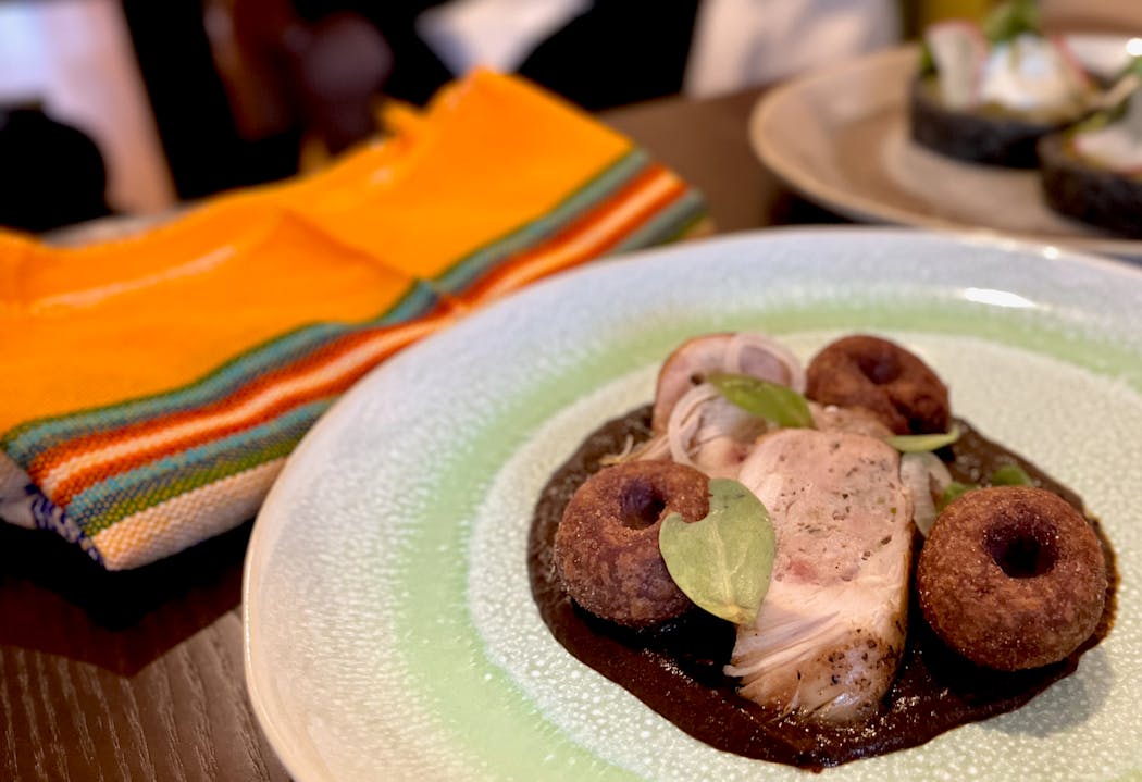 Chicken breast is deboned, stuffed, rolled and poached before being served atop a deeply colored mole.