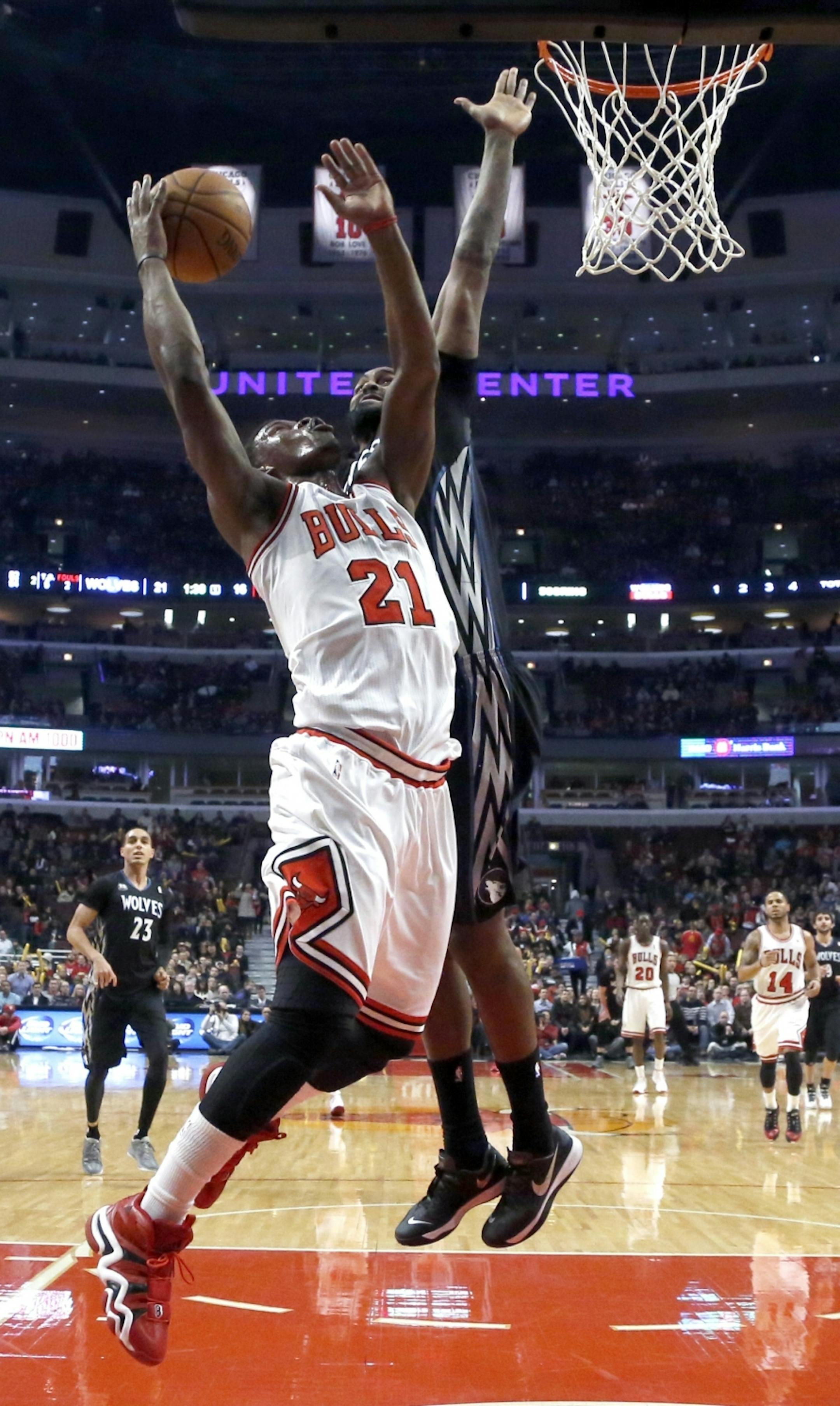 Minnesota Timberwolves center Ronny Turiaf, right, comes from behind and blocks the shot of Chicago Bulls guard Jimmy Butler during the first half of an NBA basketball game, Monday, Jan. 27, 2014, in Chicago.