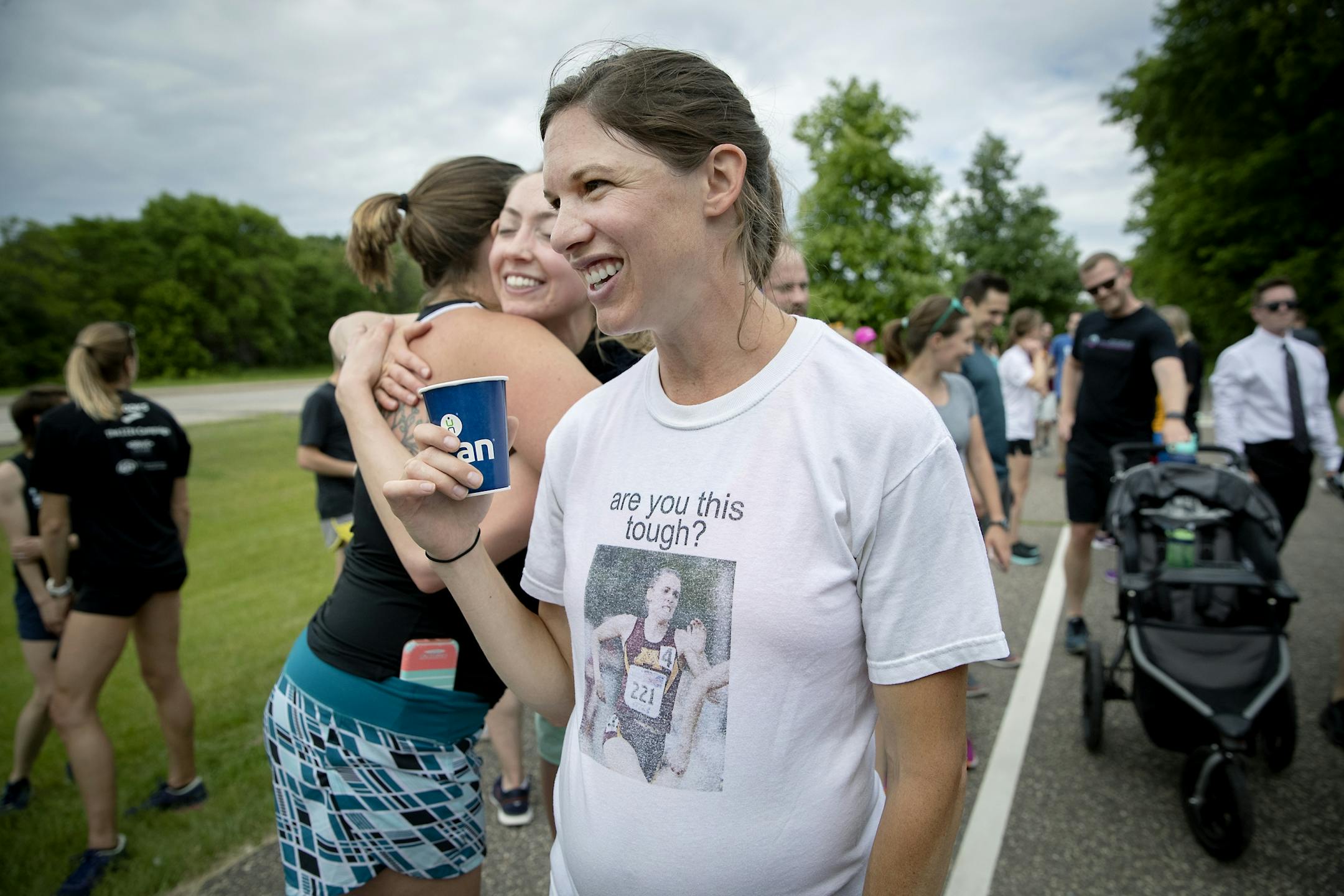Wearing a t-shirt with a photo of Gabriele Grunewald, former running teammate Elizabeth Spehar took in water and hugs after crossing the finish line following a one-mile run/jog/walk in honor Gabriele just outside Hillside Cemetery.