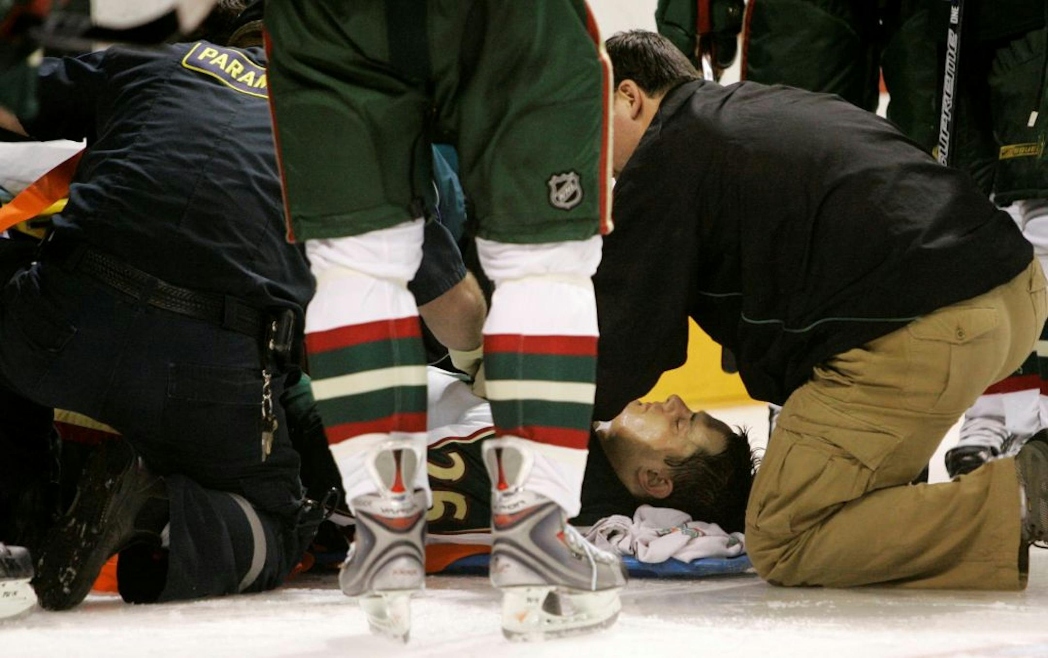 Paramedics tend to injured Minnesota Wild defenseman Kurtis Foster, bottom, after Foster collided with San Jose Sharks center Torrey Mitchell in the second period of an NHL hockey game in San Jose, Calif., Wednesday, March 19, 2008.