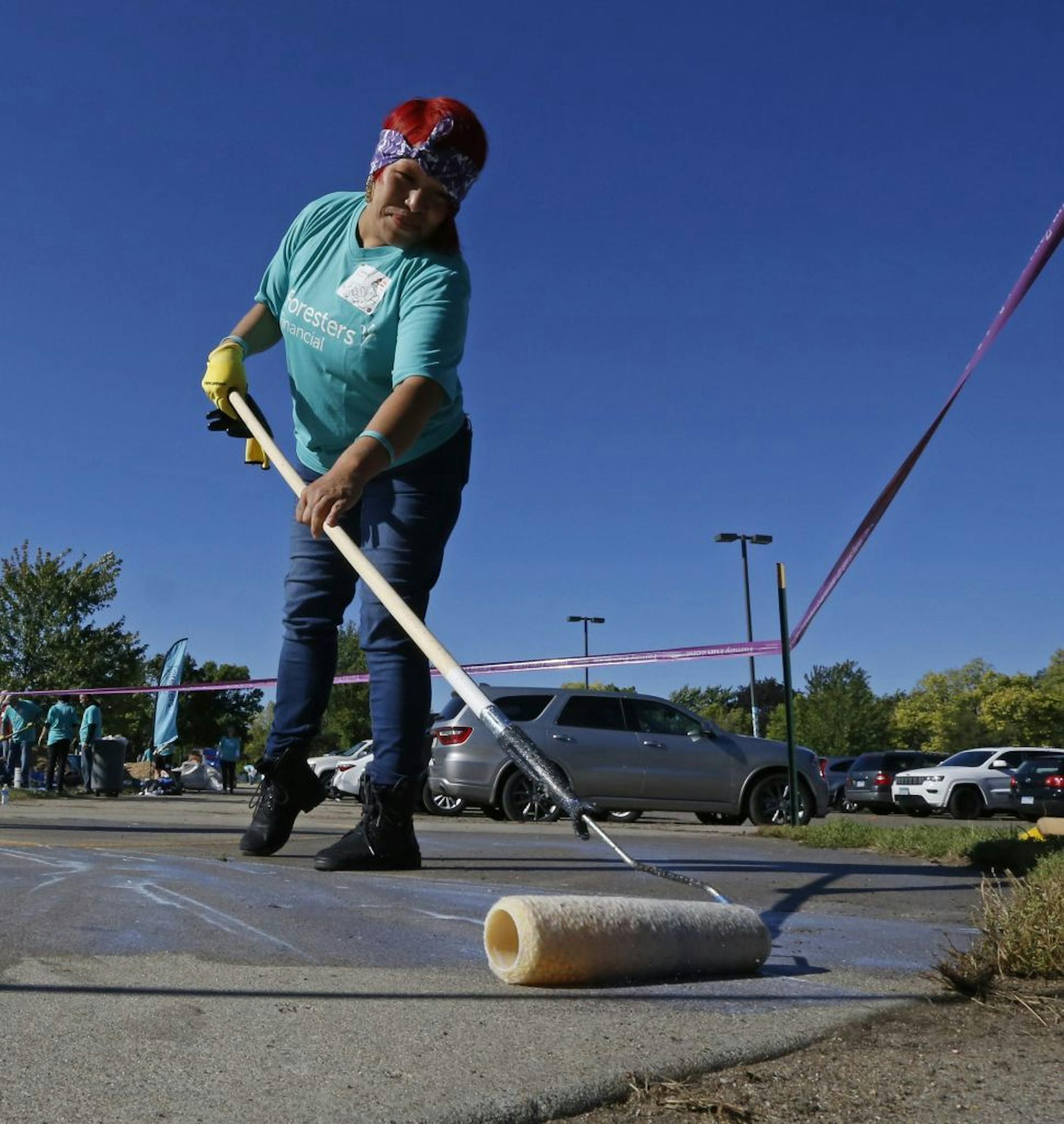 "It's a community thing. What's the community without the people," said Jessica PlentyHorse, has three children who attend Jenny Lind Elementary School. In this photo, PlentyHorse applied sealant to the sidewalk outside the school.