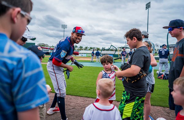 Twins outfielder Byron Buxton (25) signed balls for kids during batting practice.