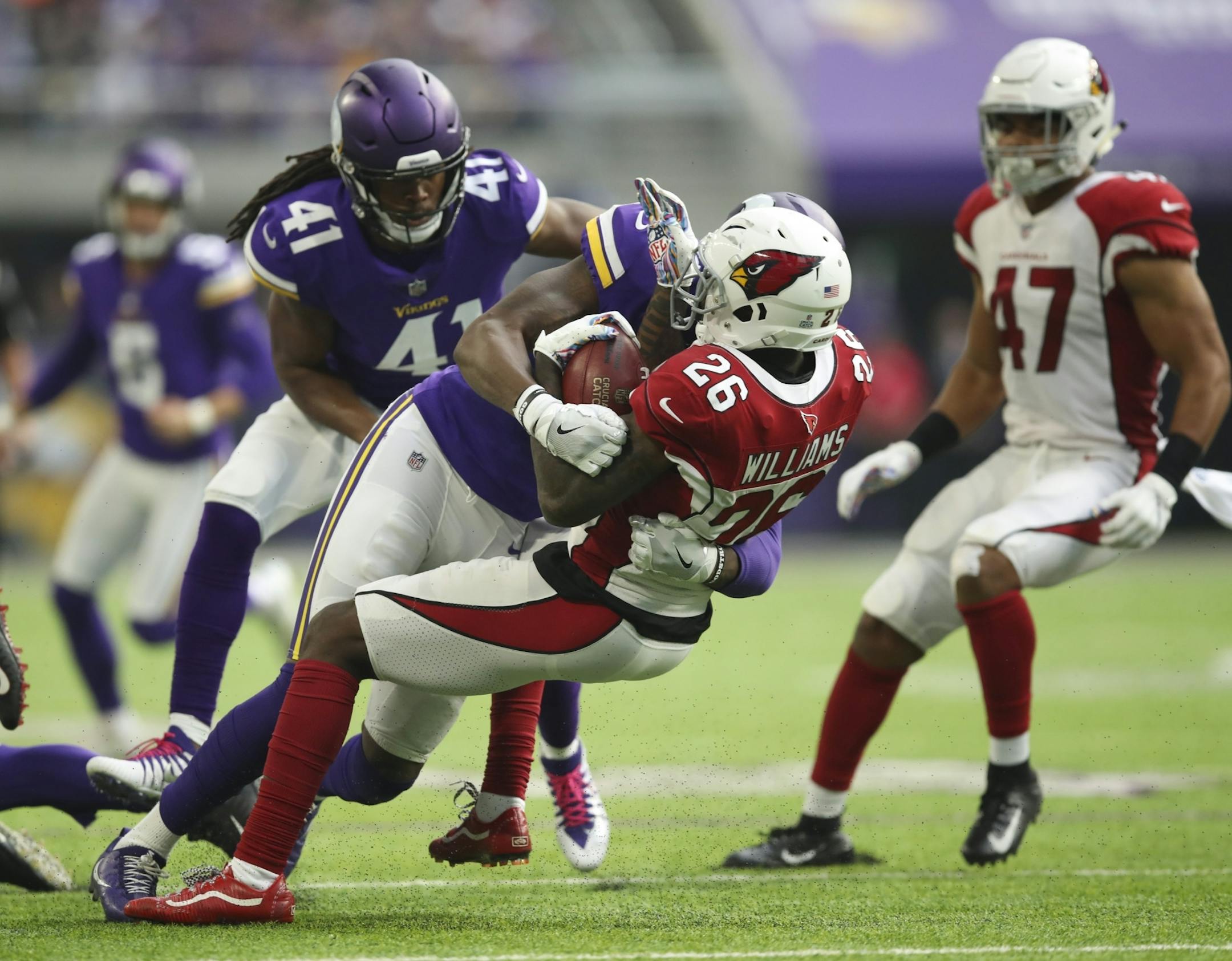Brandon Williams (26) was stopped by Vikings defensive back George Iloka (23).
