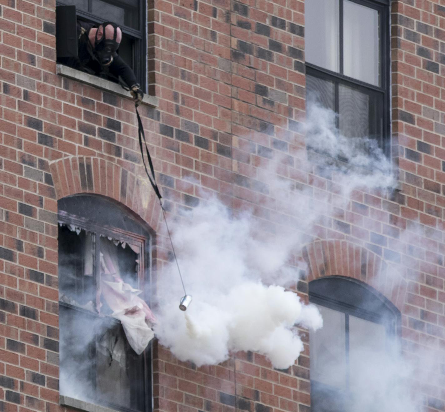 A police man leaned out window and used a tool to throw a can of tear gas into a window where a suspect had been on a stand off with police for over a day on Tuesday, January 30, 2018, at the Graduate Hotel at the University of Minnesota in Minneapolis, Minn. ] RENEE JONES SCHNEIDER &#x2022; renee.jones@startribune.com