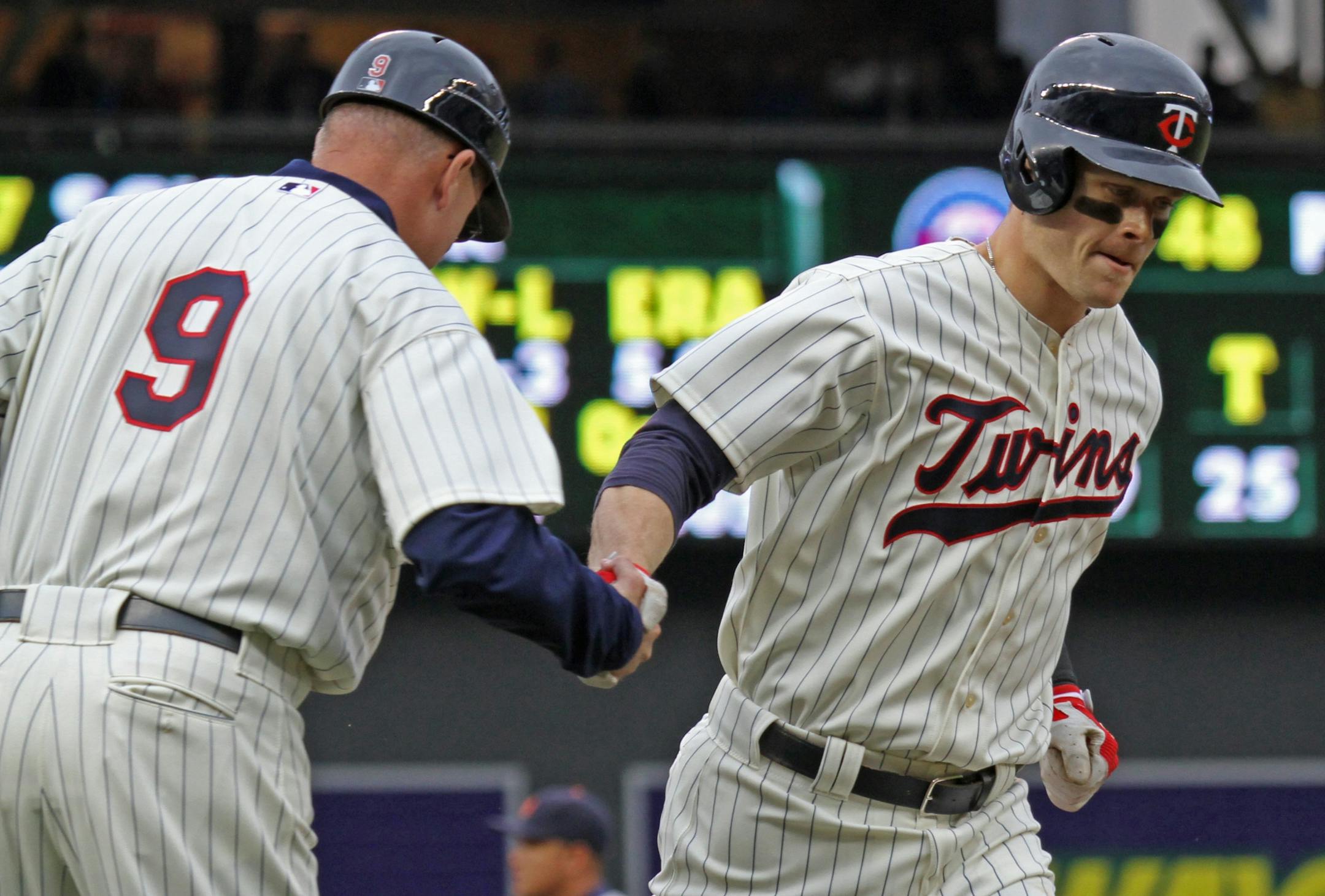 Minnesota Twins vs Detroit Tigers, Target Field, 5/26/12. (left to right) 3rd base coach Steve Liddle celebrated with Twin Justin Morneau as he rounded the bases after hitting a 2nd inning home run.