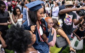 High school graduate Ashely Nyamari is lifted up by her aunts during a traditional Kenyan graduation ceremony dance at Mariucci Arena in Minneapolis o