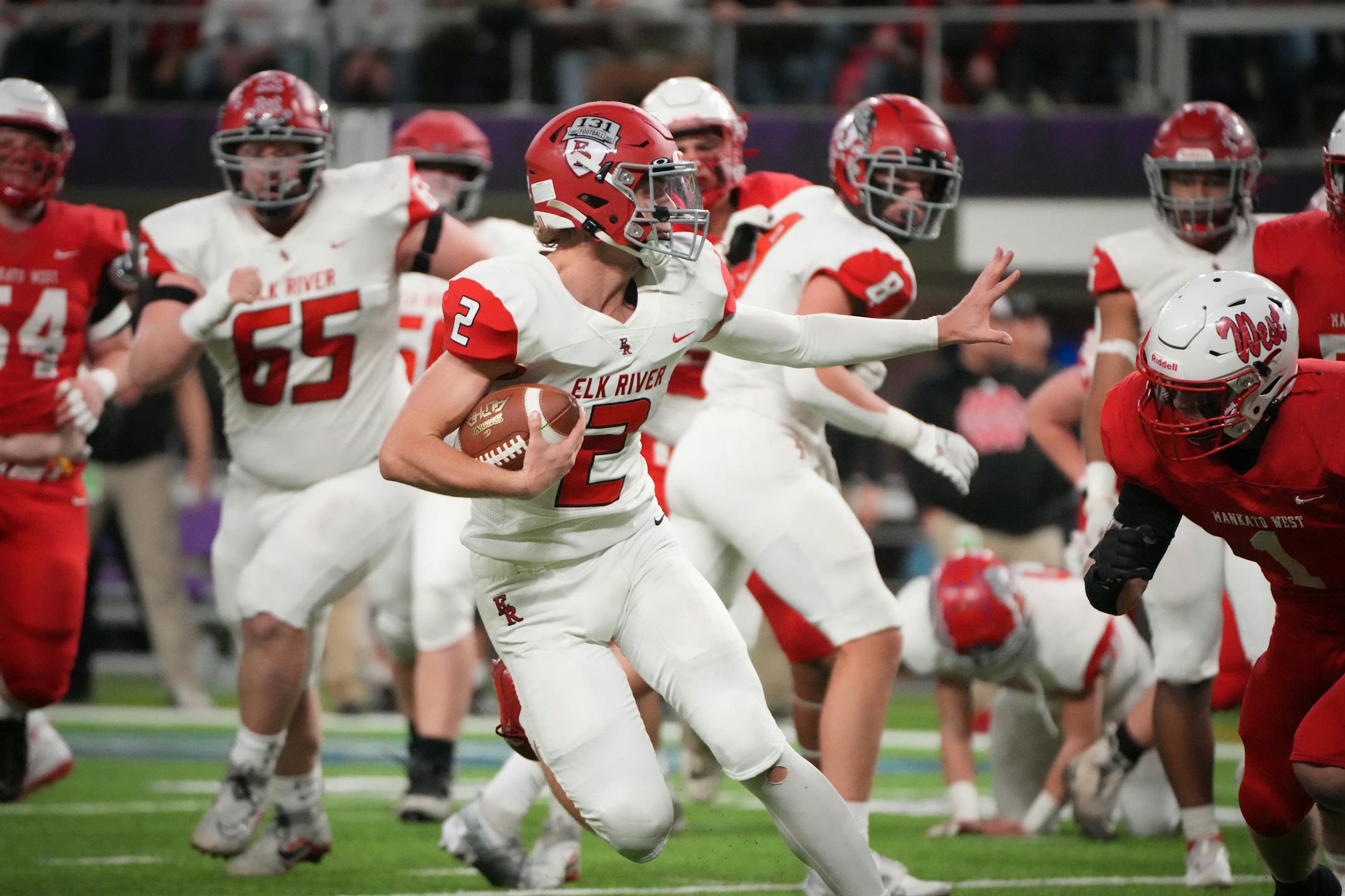 Elk River's Cade Osterman (2) holds off a tackle by Mankato West's Damian Riewe (1) to score a touchdown in the first half of the Minnesota High School football Class 5A State Championship at U.S. Bank Stadium in Minneapolis, Minn., on Saturday, Dec. 3, 2022.