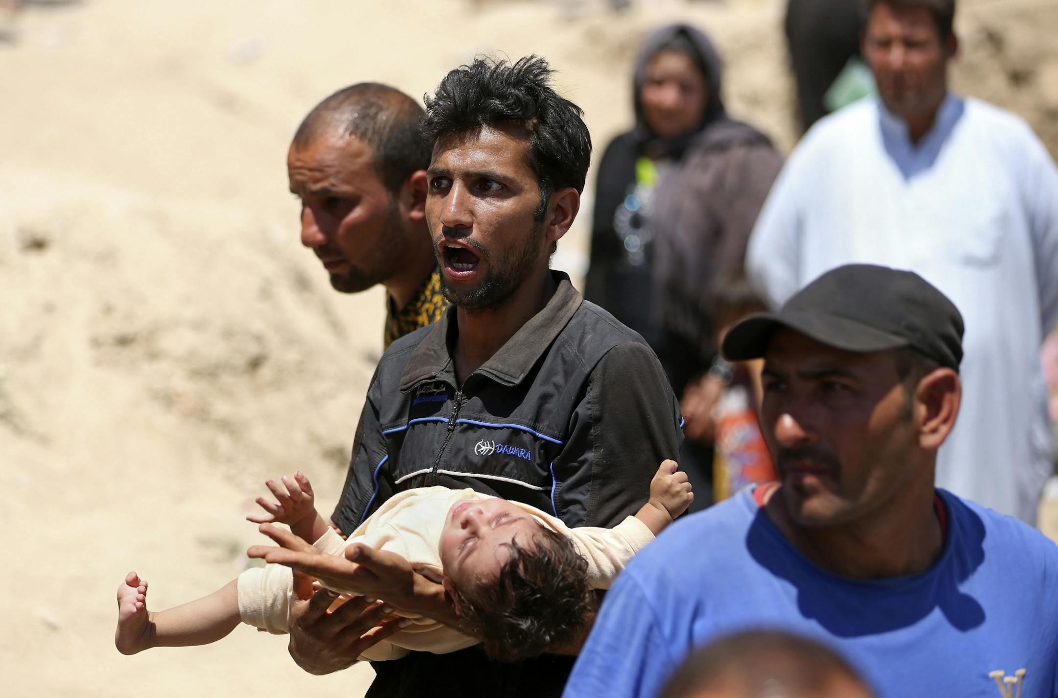 Displaced Iraqis from Ramadi cross the Bzebiz bridge after spending the night walking towards Baghdad, as they flee their hometown, 65 km west of Baghdad, Iraq, Saturday, May 16, 2015. Islamic State militants seized the center of Ramadi in western Iraq and raised their black flag over the government compound, local officials said.