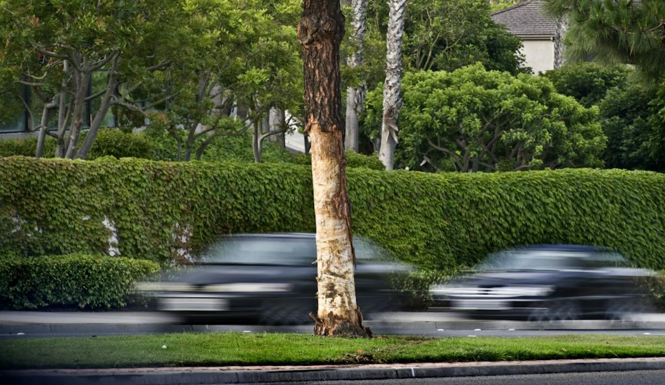 Cars drive past the scene of a Monday fiery car crash that killed five, Tuesday, May 28, 2013 in Newport Beach, Calif.