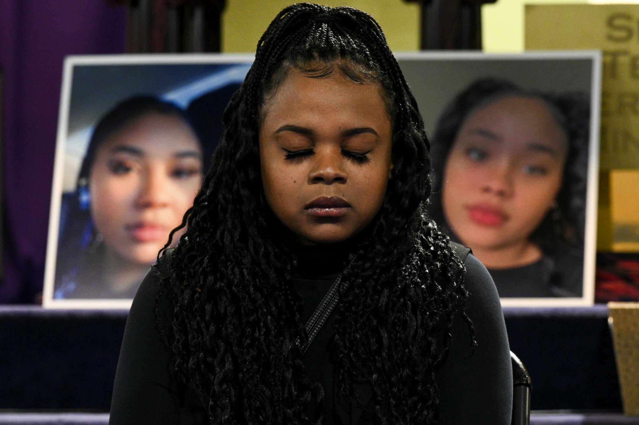 Shontell Bishop, cousin of Zaria McKeever, bows her head in prayer as photos of McKeever are displayed behind her Wednesday at Shiloh Temple in Minneapolis.