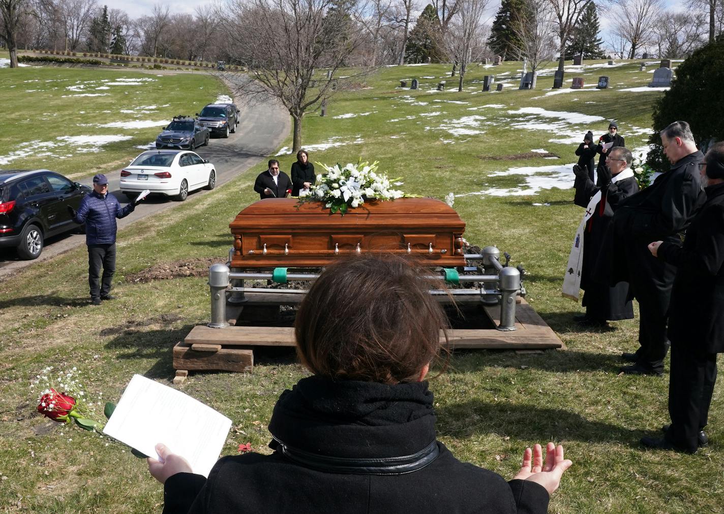 Relatives and friends including granddaughter Elianne Farhat, center, prayed during funeral services for Elie Farhat, who recently died of COVID-19 at the age of 92.