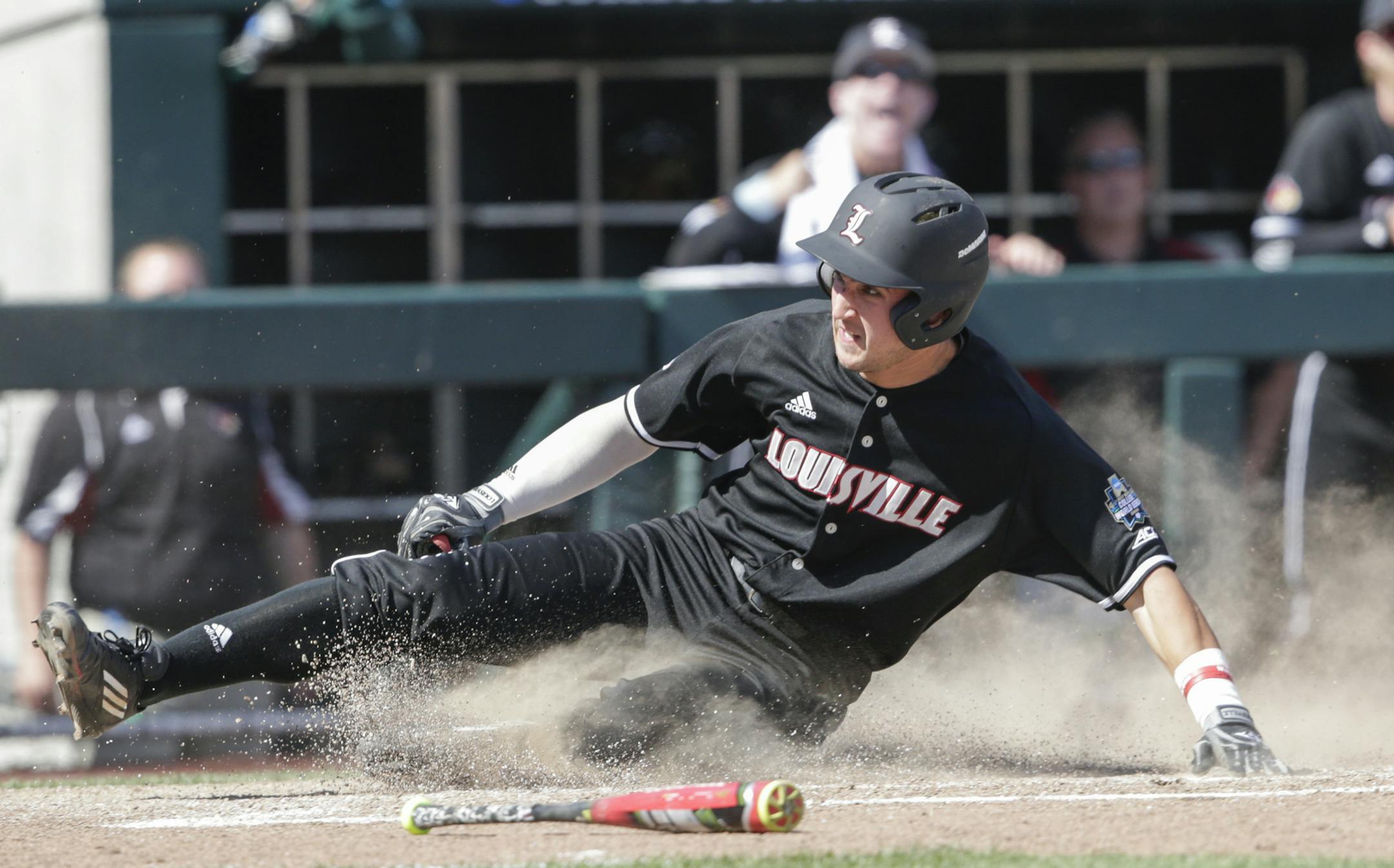 Louisville's Ryan Summers scores at home on a single by Colby Fitch, who later advanced to second base on an error, in the eighth inning of an NCAA College World Series baseball game against Texas A&M in Omaha, Neb., Sunday, June 18, 2017. Louisville won 8-4. (AP Photo/Nati Harnik)