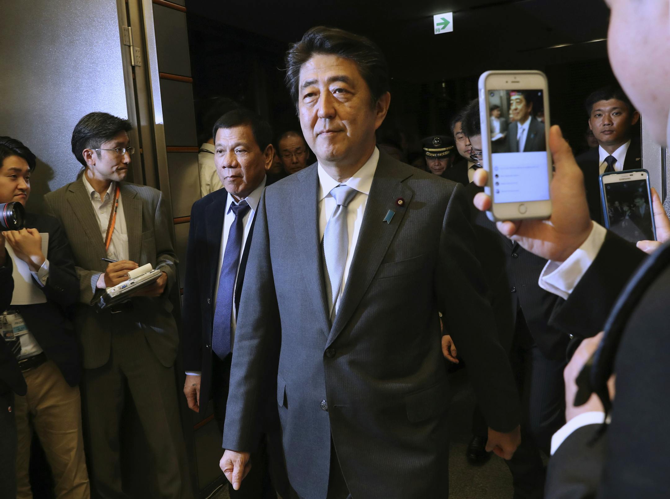 Philippine President Rodrigo Duterte, third from left, is escorted by Japanese Prime Minister Shinzo Abe, center, to the venue of a joint press conference following their meeting at Abe's official residence in Tokyo, Wednesday, Oct. 26, 2016. (AP Photo/Eugene Hoshiko, Pool) ORG XMIT: XEH117