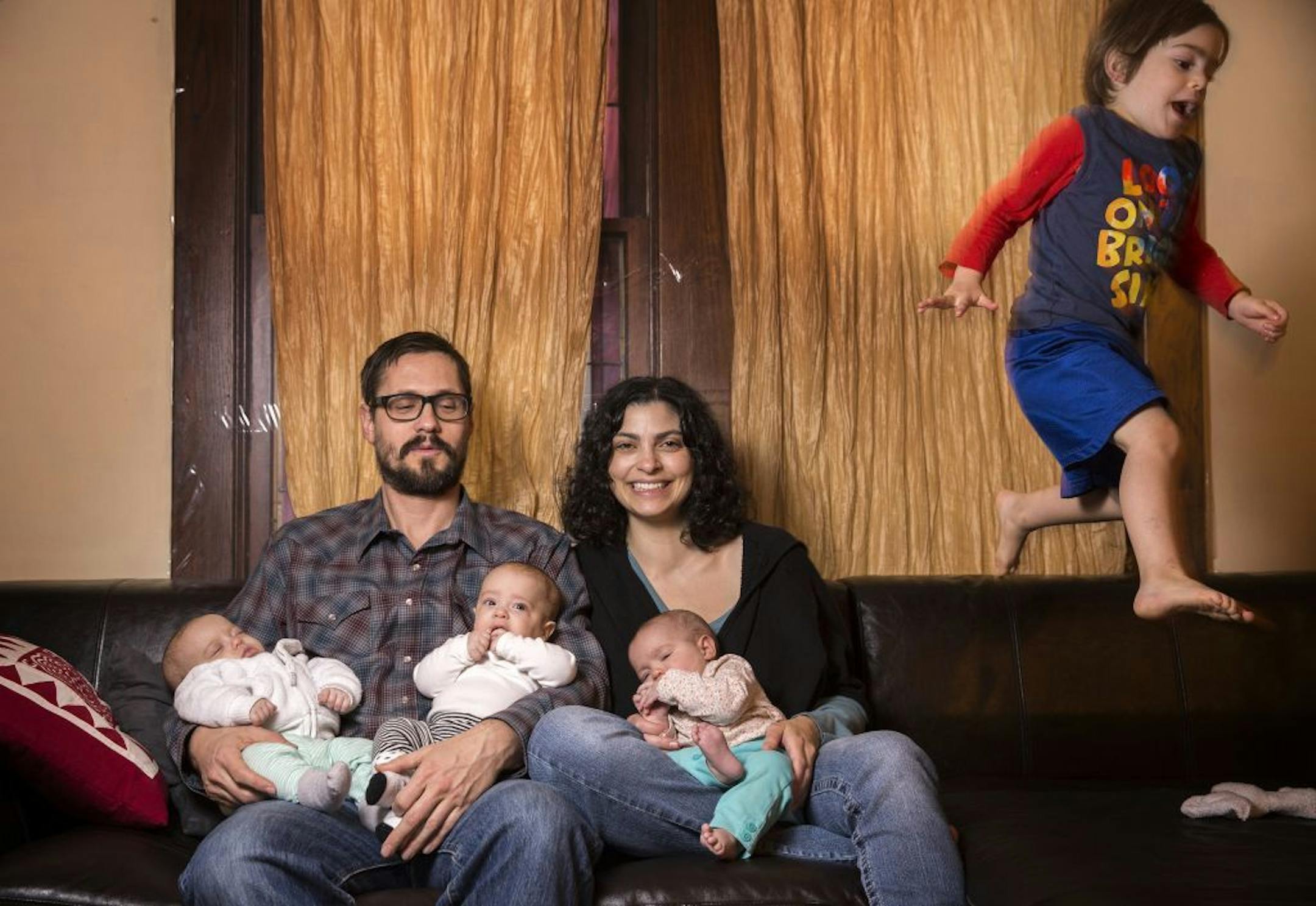 Kurt Froehlich and Jen March pose in their Minneapolis home with their triplets and young son on Monday, November 16, 2015. The March Froehlich family will be hosting their first Thanksgiving since having triplets.