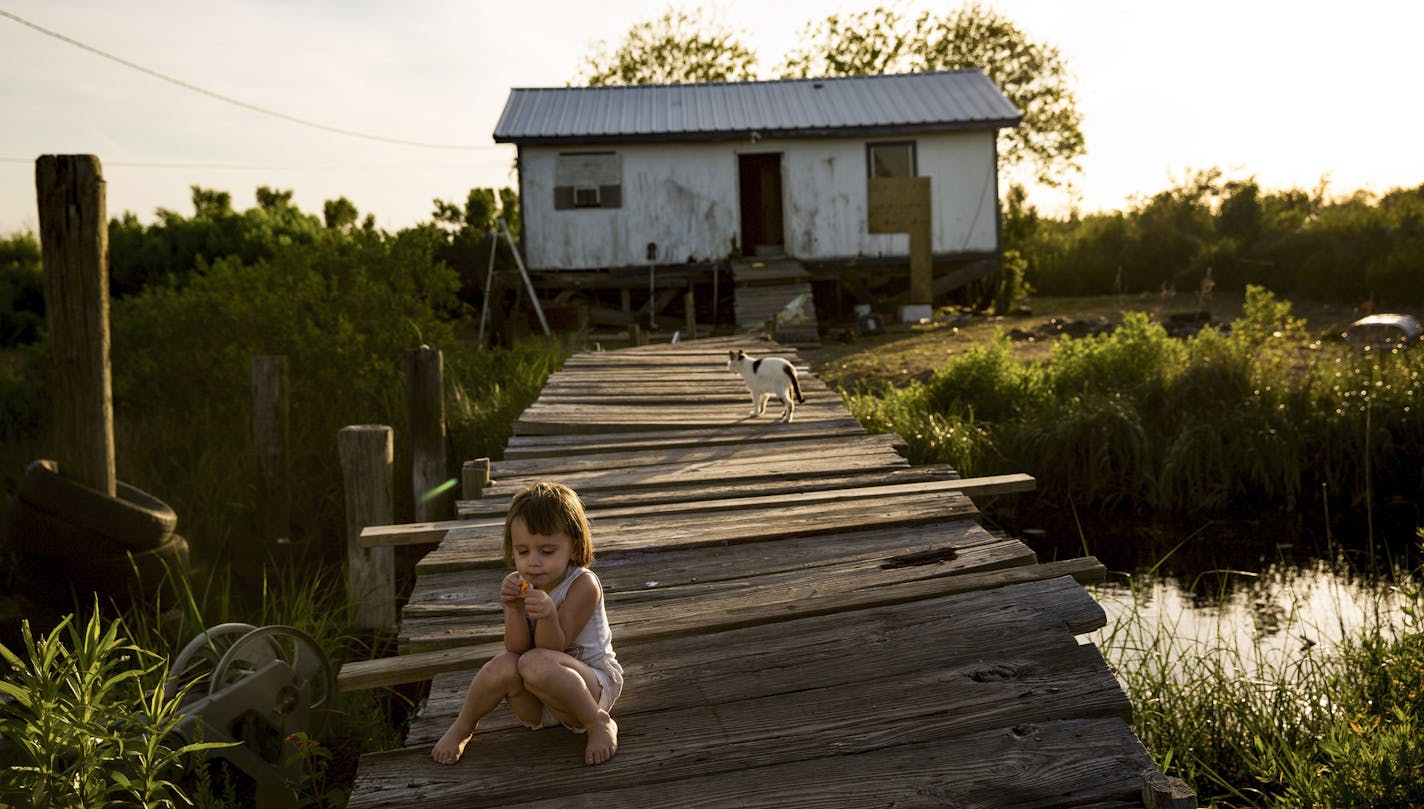 Amiya Brunet, 3, on the bridge that leads to her home that frequently floods in Isle de Jean Charles, La., April 7, 2016. A $48 million grant for Isle de Jean Charles is the first allocation of federal tax dollars to move an entire community struggling with the effects of climate change. (Josh Haner/The New York Times) ORG XMIT: XNYT133