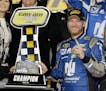 Dale Earnhardt Jr poses with the trophy in Victory Lane after winning the first of two qualifying races for Sunday's NASCAR Daytona 500 Sprint Cup ser