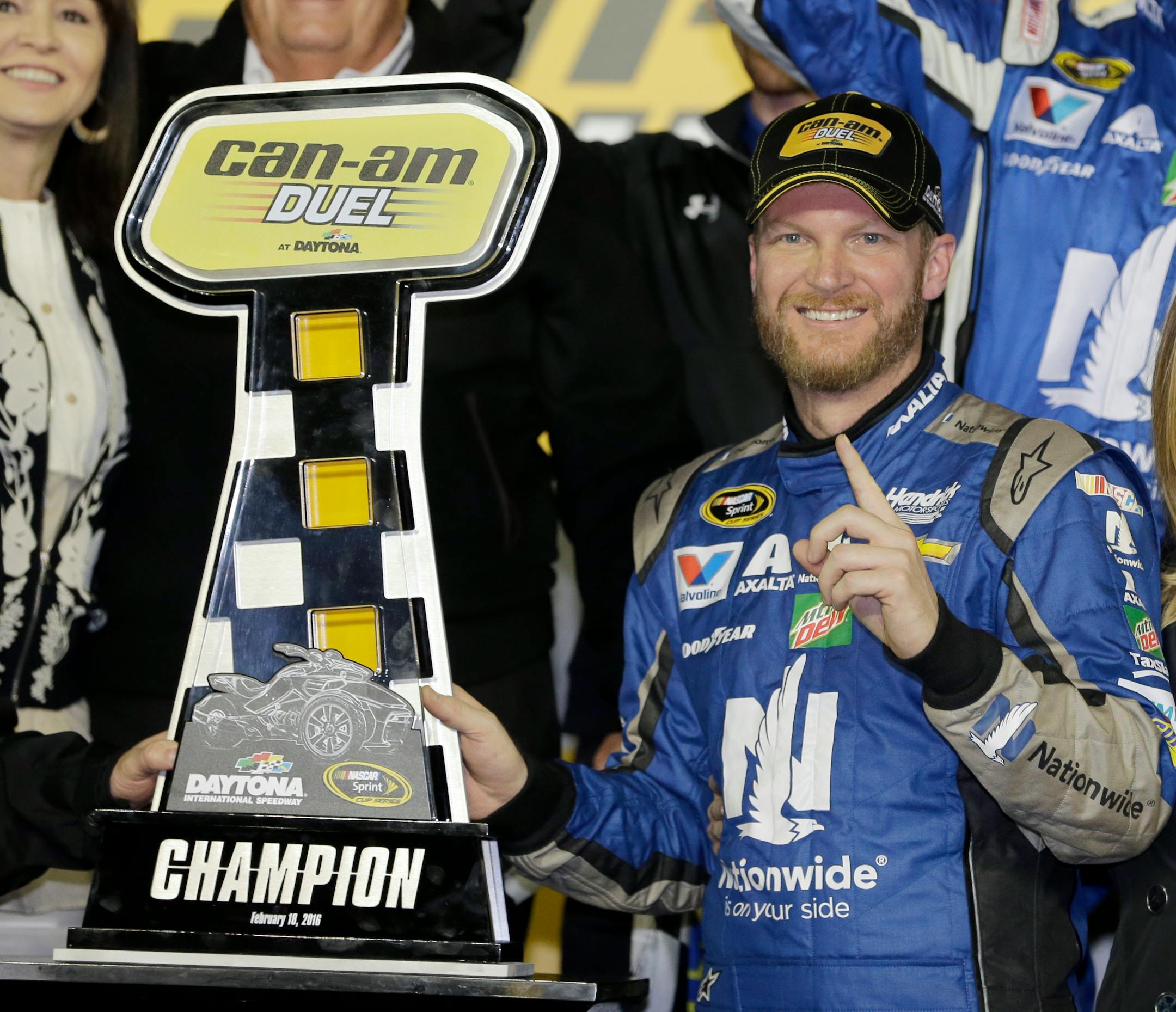 Dale Earnhardt Jr poses with the trophy in Victory Lane after winning the first of two qualifying races for Sunday's NASCAR Daytona 500 Sprint Cup series auto race at Daytona International Speedway in Daytona Beach, Fla., Thursday, Feb. 18, 2016. (AP Photo/Terry Renna)