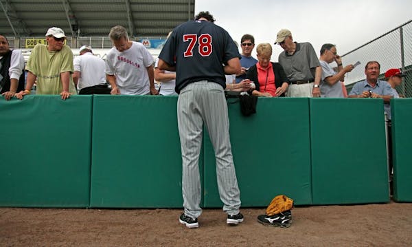 Seven-foot-1 Loek van Mil towered over fans as he stopped to sign autographs at the end of a twins spring training workout in 2010.