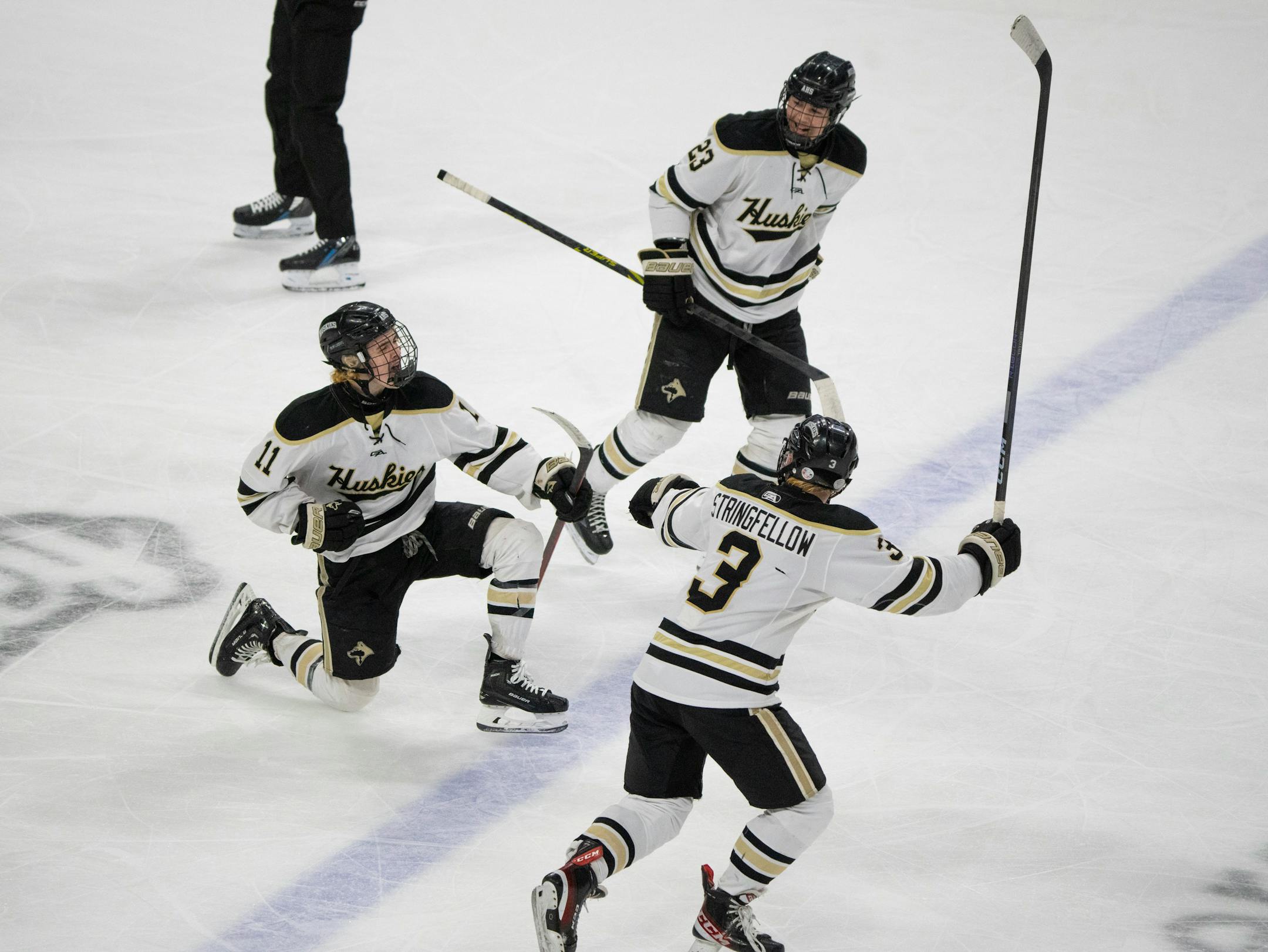 Andover Huskies forward Brooks Cogswell (11) celebrated his third period goal with teammates Landon Stringfellow (3) and Anthony Pardo (23).